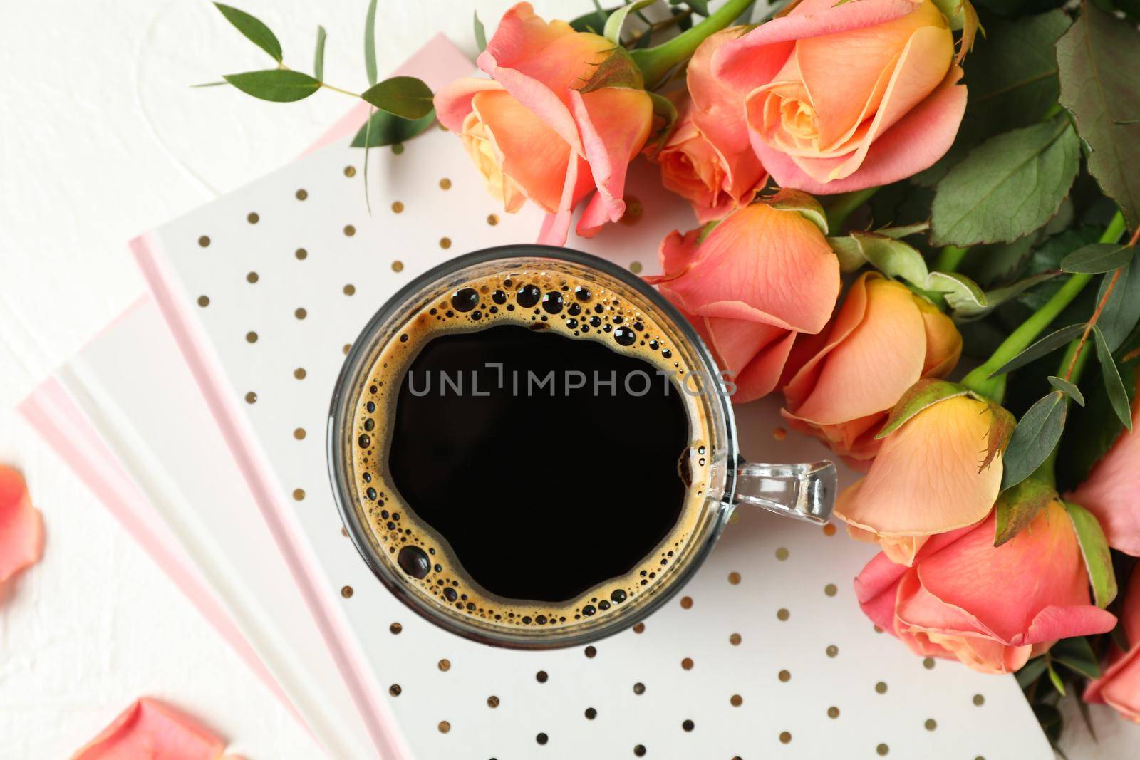 Composition with cup of coffee, notebooks and pink roses on white background, top view by AtlasCompany