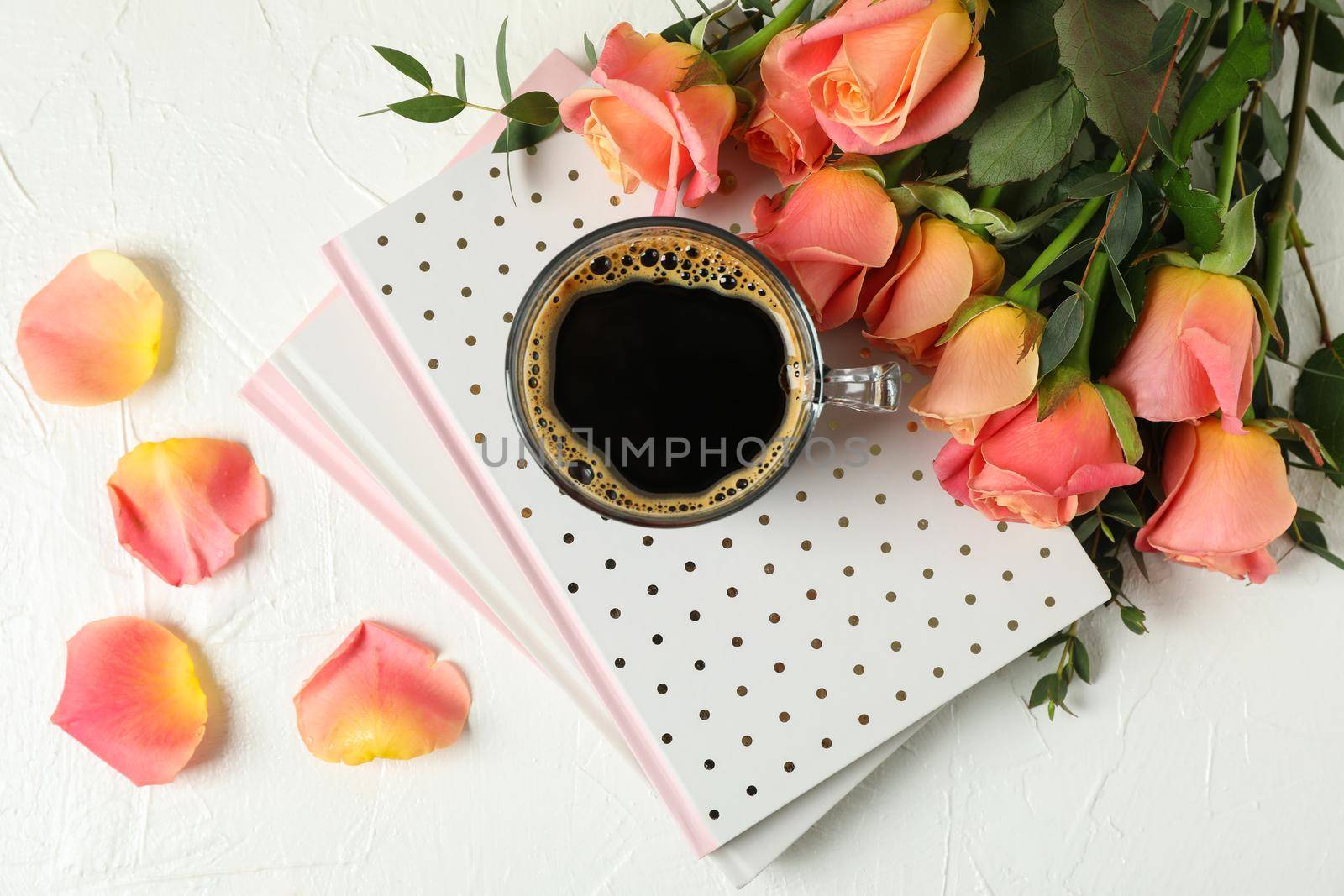 Composition with cup of coffee, notebooks and pink roses on white background, top view by AtlasCompany