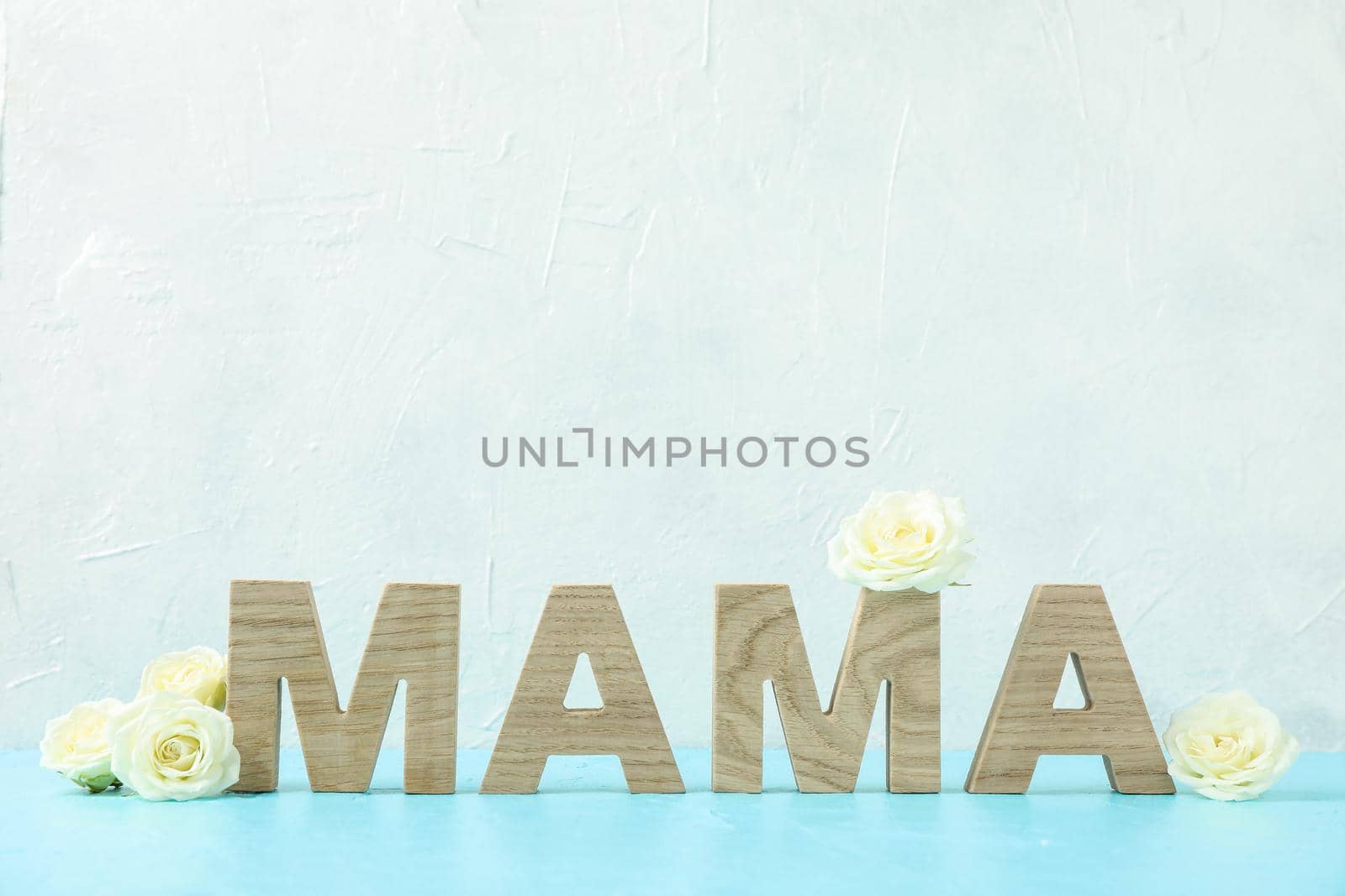 Inscription Mom with white roses on blue table against white background, space for text by AtlasCompany