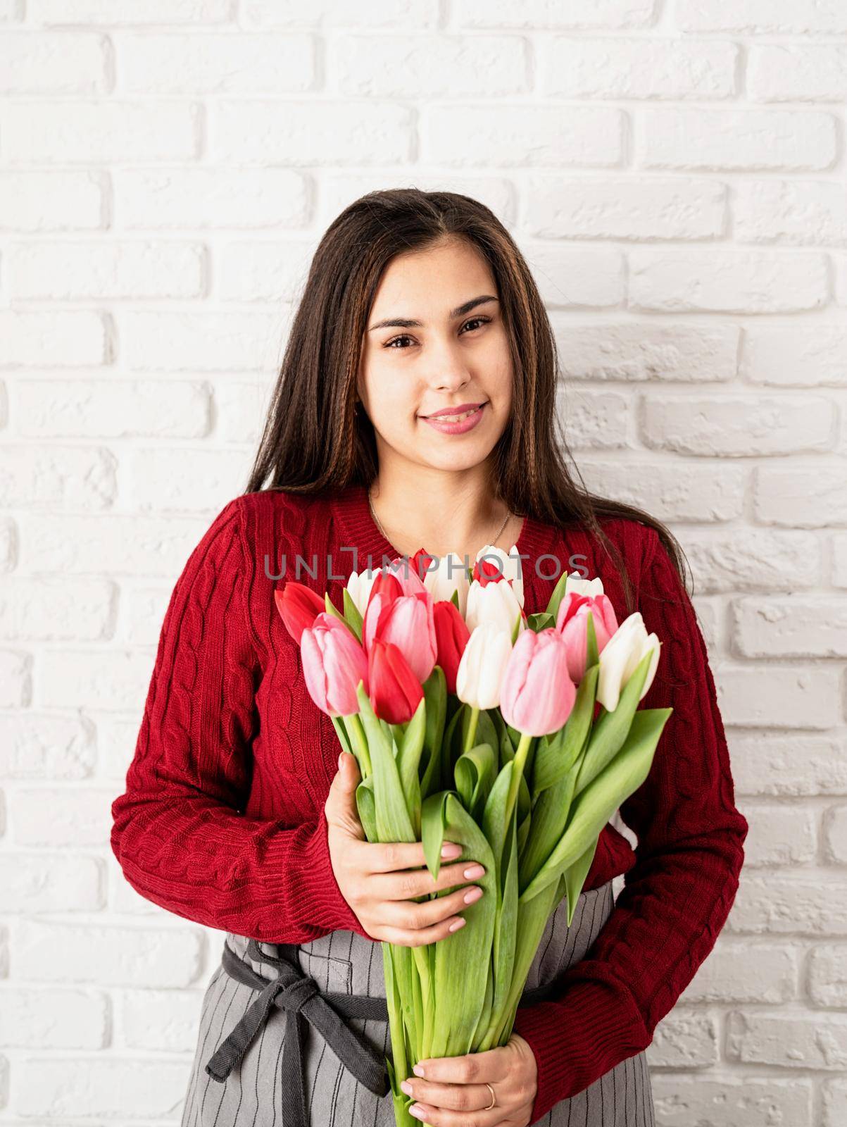 Woman florist holding a bouquet of fresh colorful tulips by Desperada