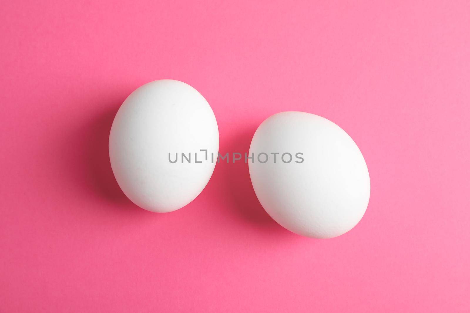 Chicken eggs on pink background, space for text by AtlasCompany
