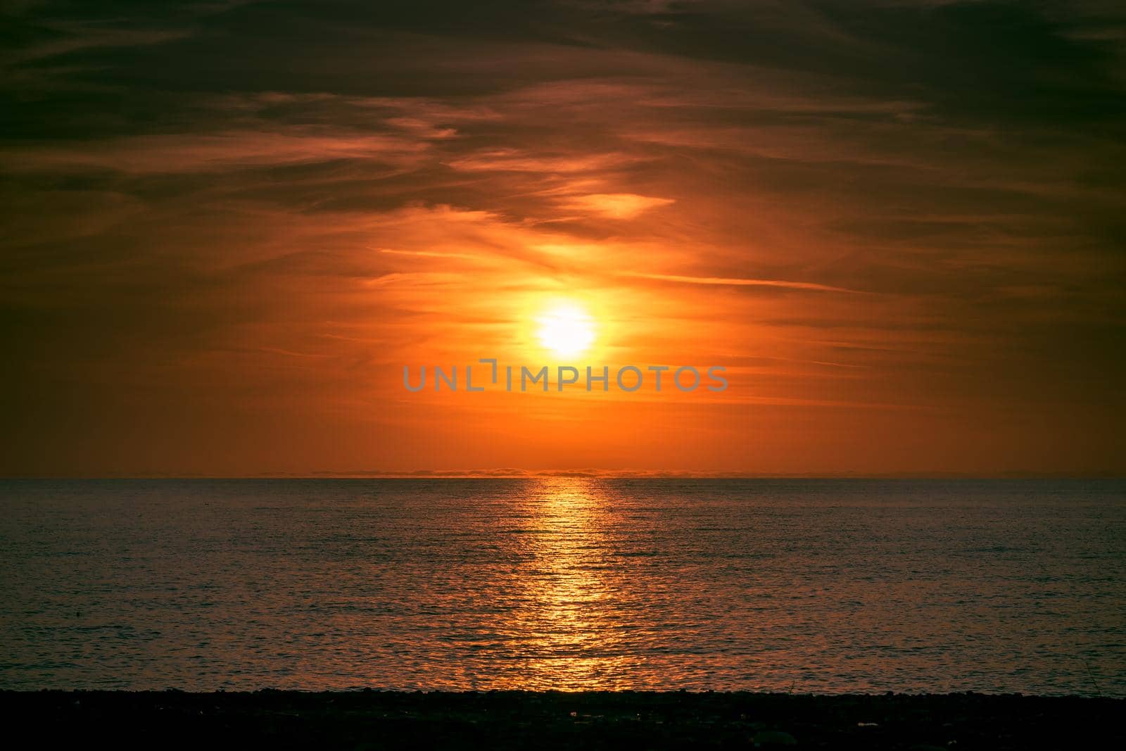 Seascape with a beautiful sunset over the horizon and the water surface.