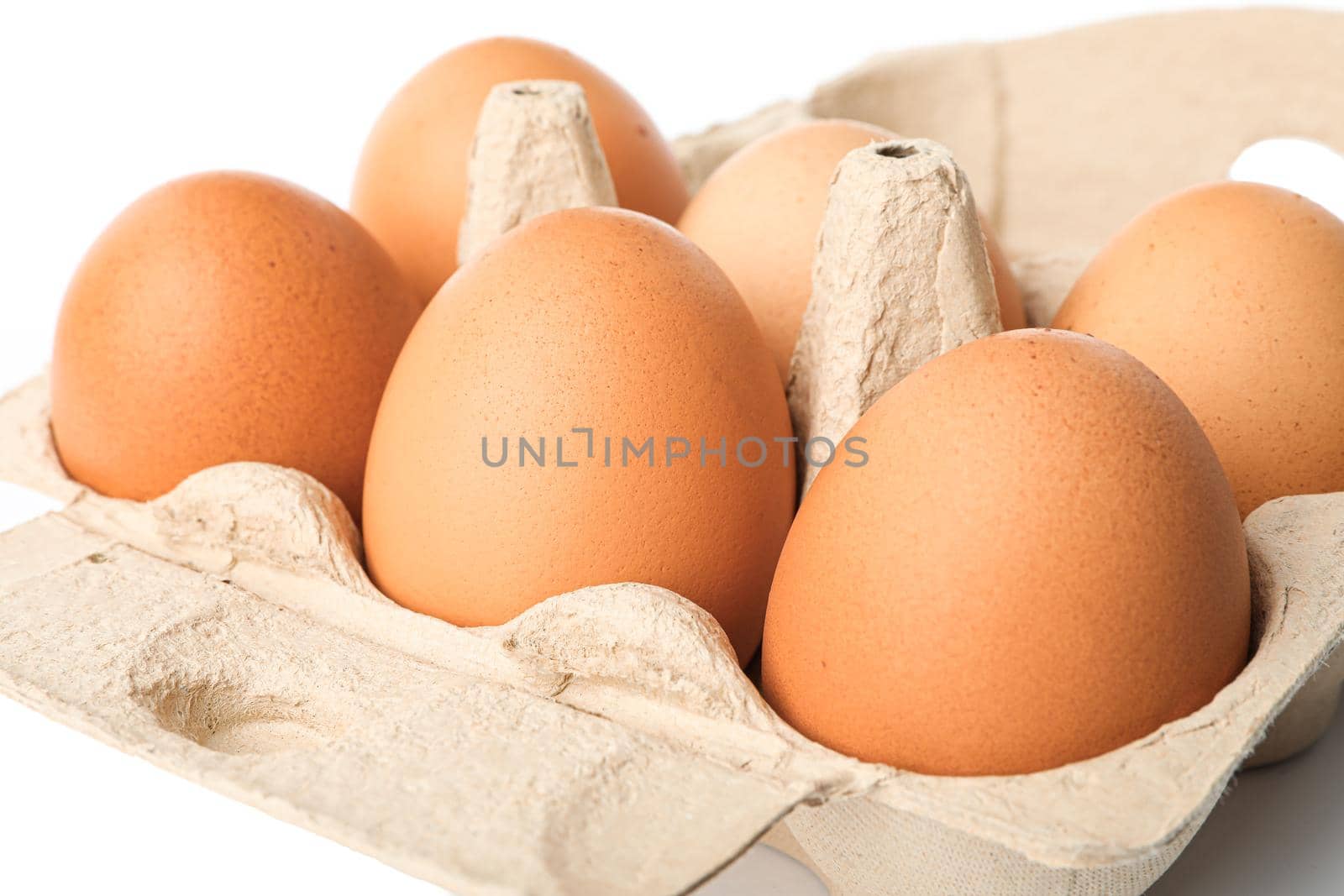 Brown chicken eggs in carton box isolated on white background. closeup