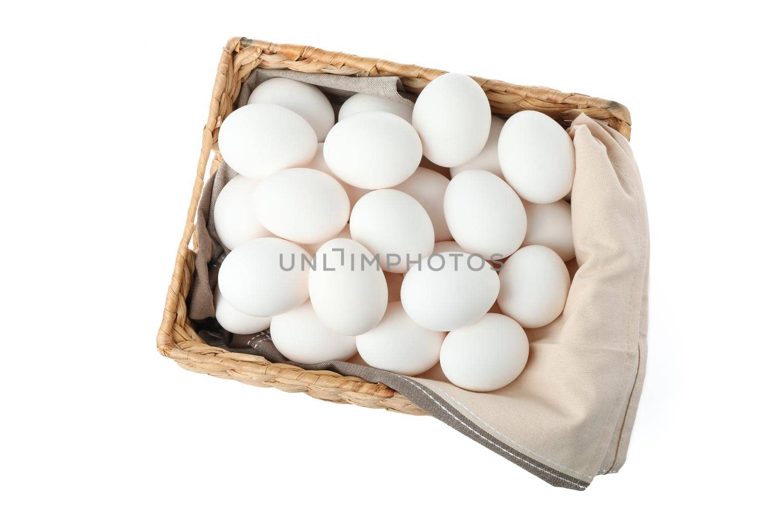 Chicken eggs with kitchen towel in straw basket isolated on white background, top view