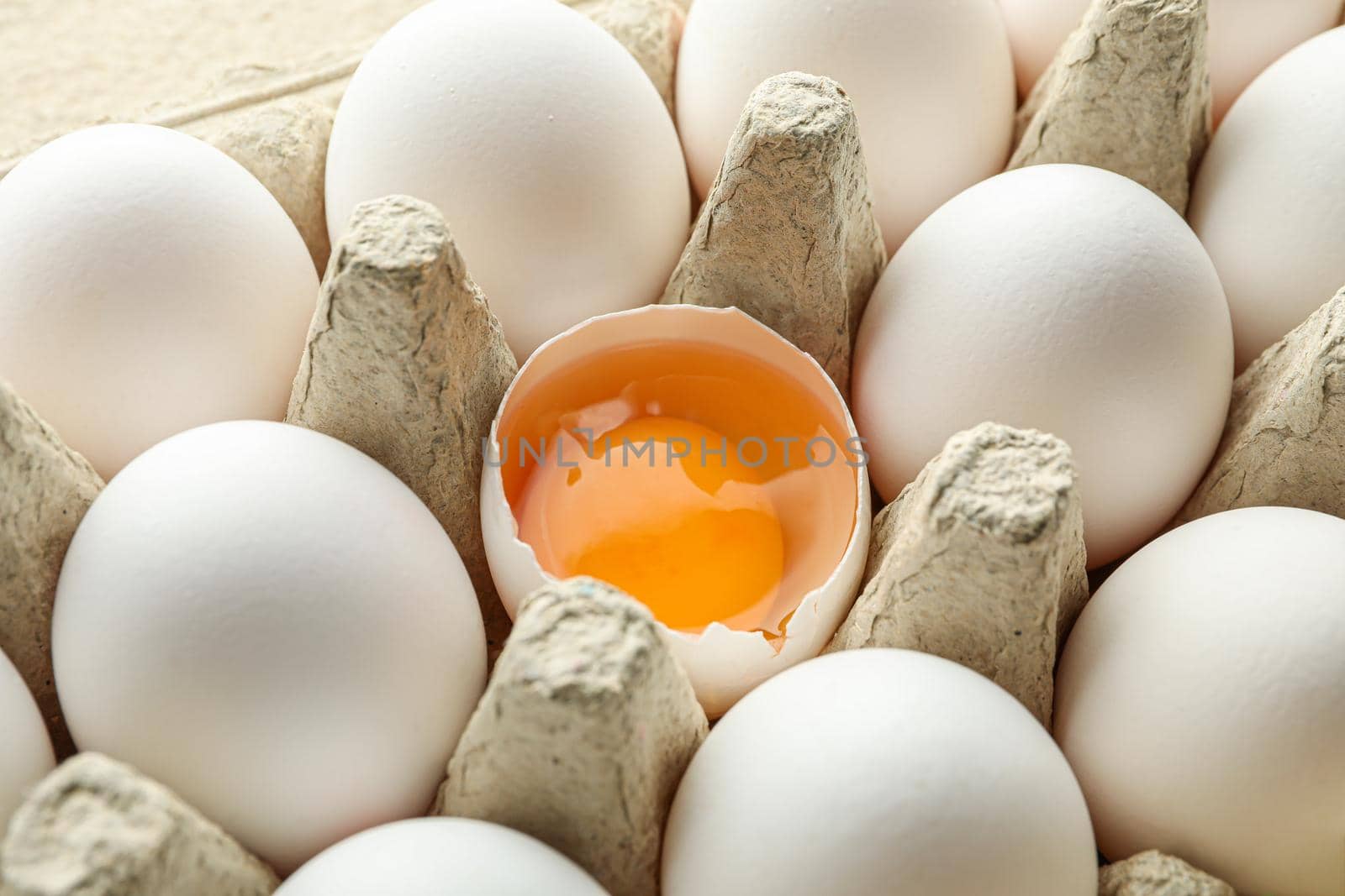 White chicken eggs in carton box as background, closeup by AtlasCompany