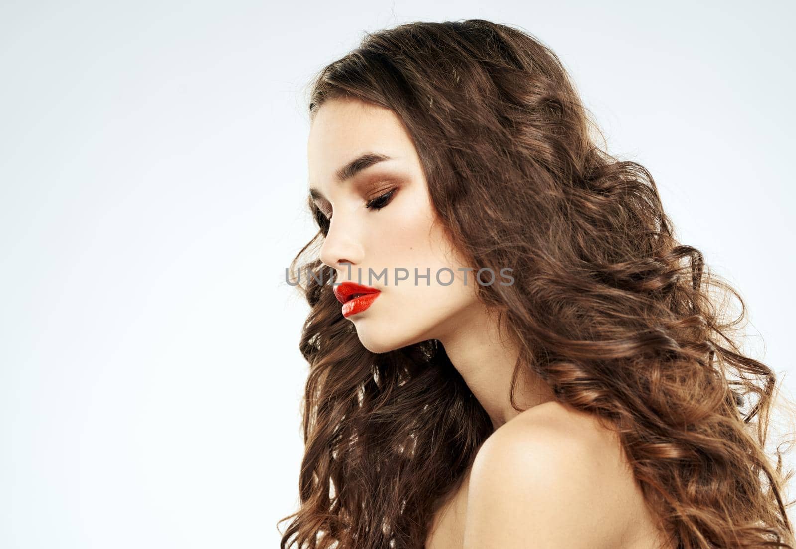 Side view of lady with curly hair red lips. High quality photo