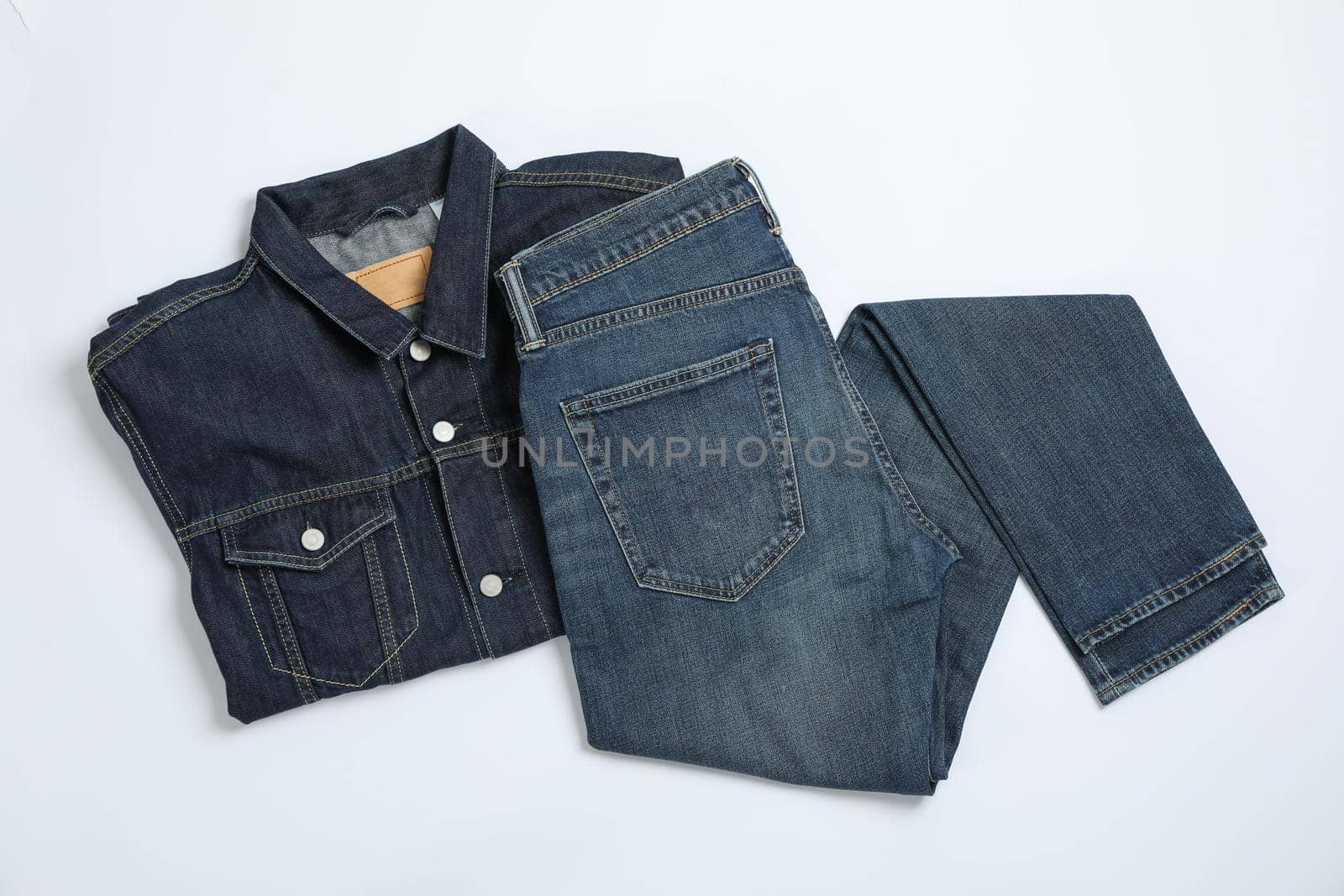 Denim jacket and pants on white background, space for text by AtlasCompany