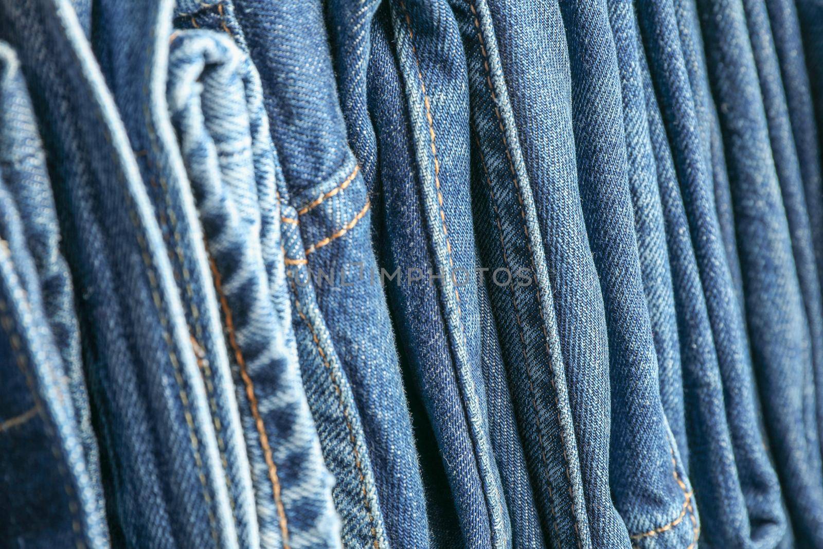Stack of blue jeans as background, space for text