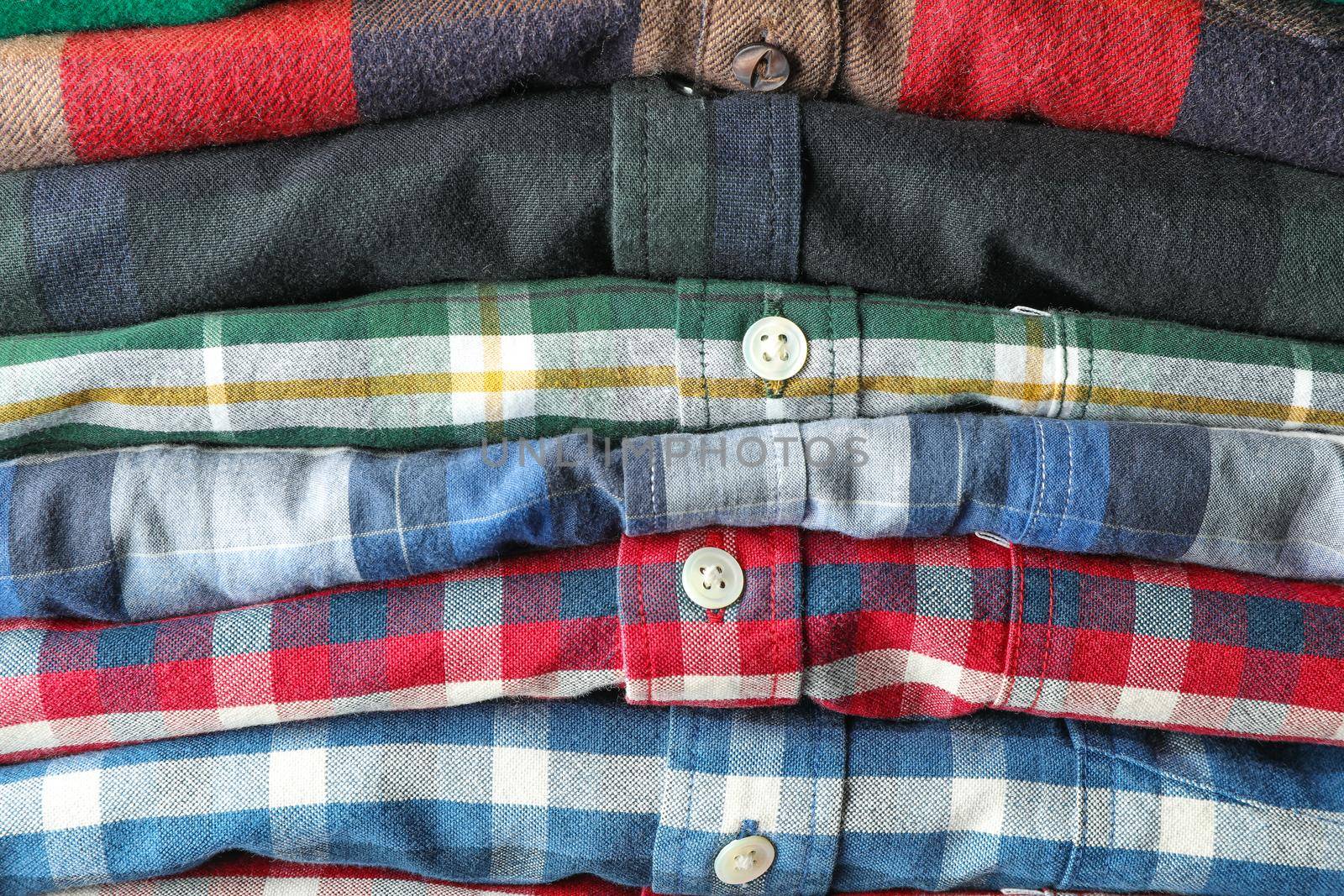 Stack of colorful shirts as background, space for text