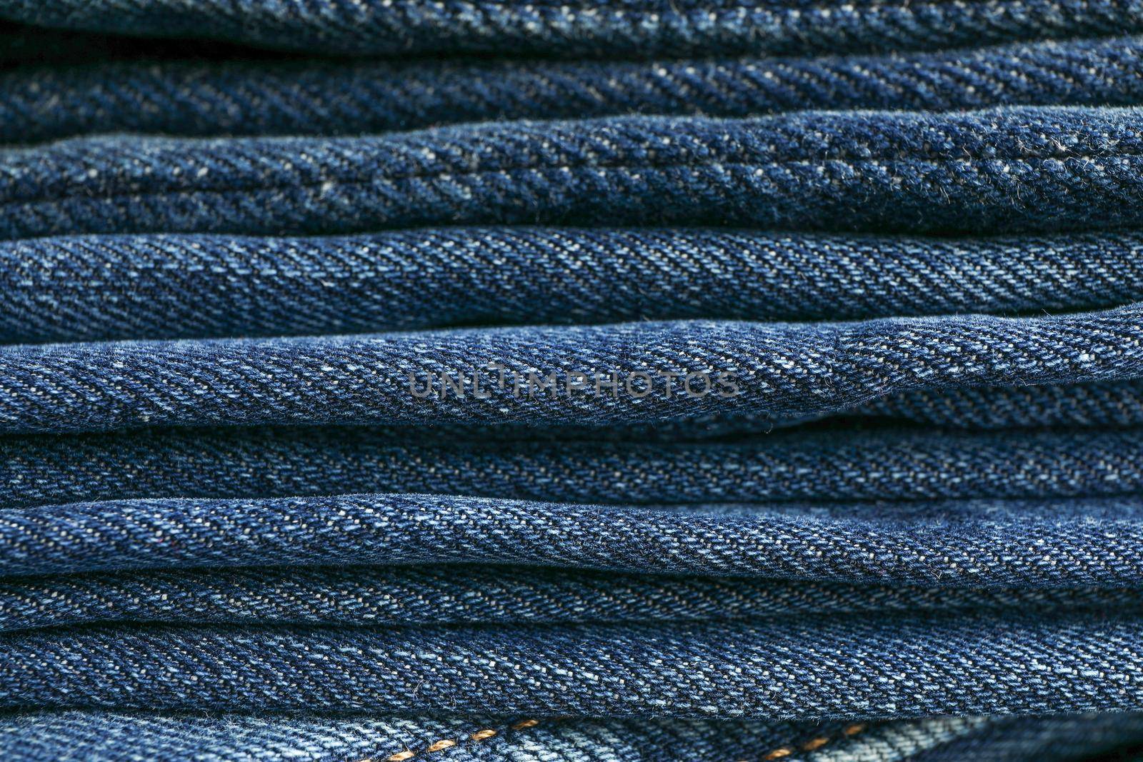 Stack of blue jeans as background, space for text