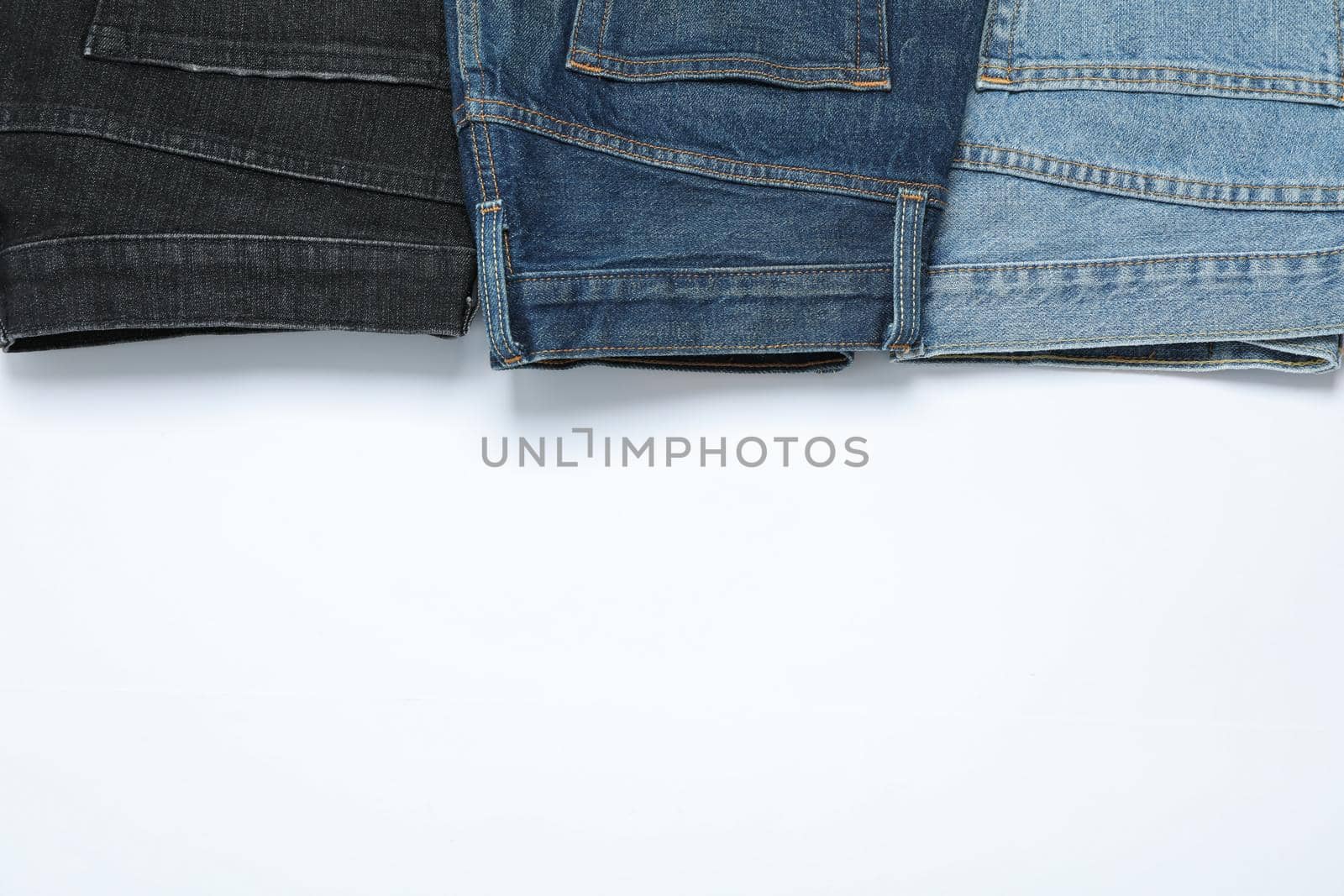 Flat lay with jeans on white background, copy space