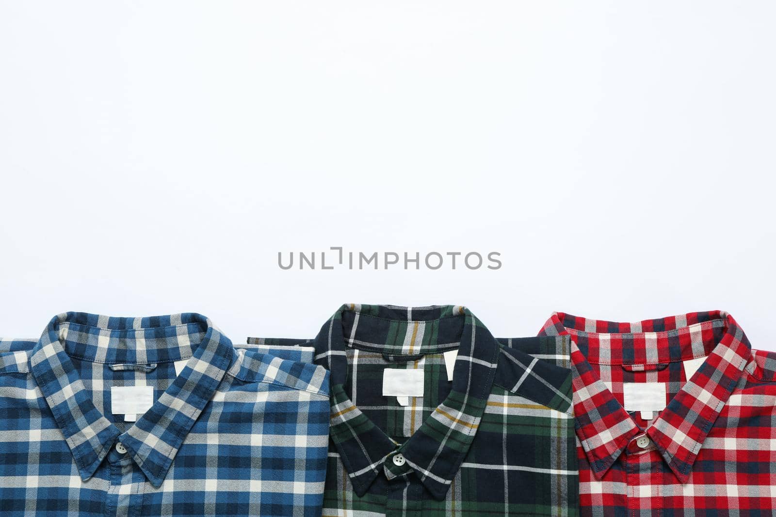 Flat lay with shirts on white background, copy space