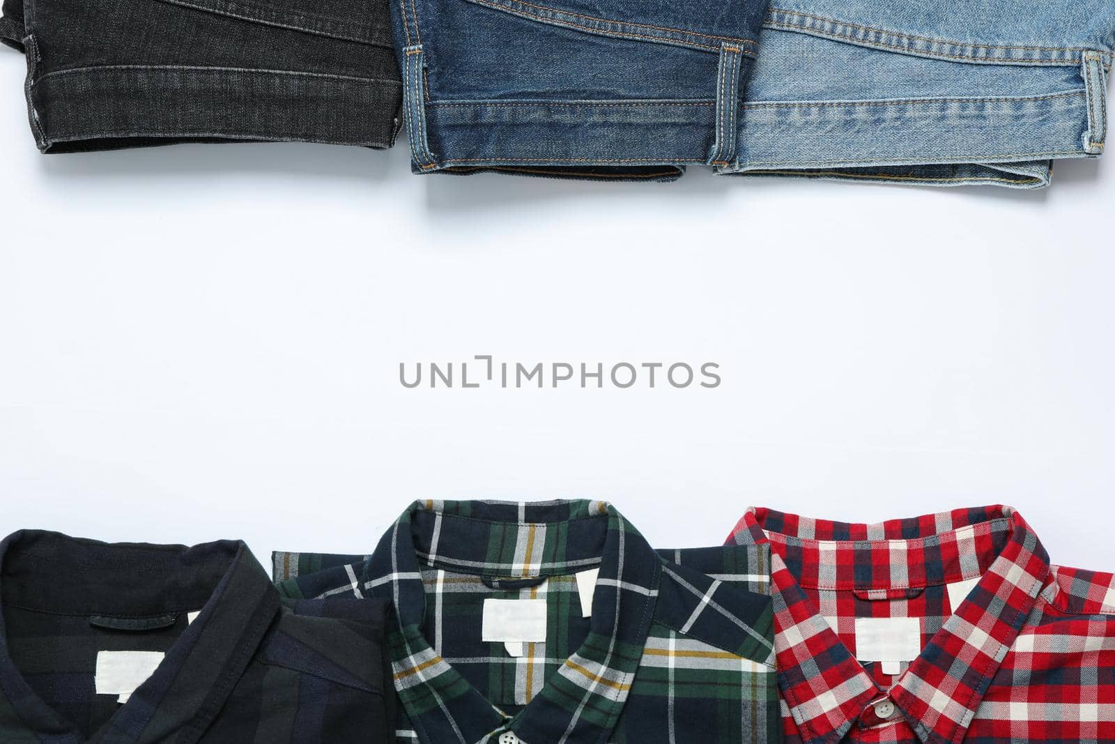 Flat lay with shirts and jeans on white background by AtlasCompany