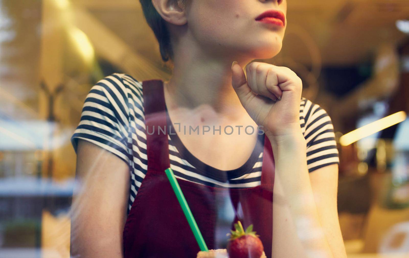 fashionable woman in red sundress resting in a cafe with a drink in her hand. High quality photo