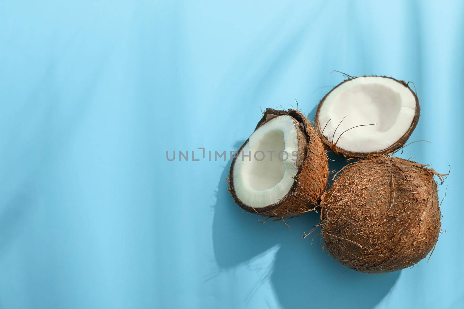 Two coconut one of which split on color background