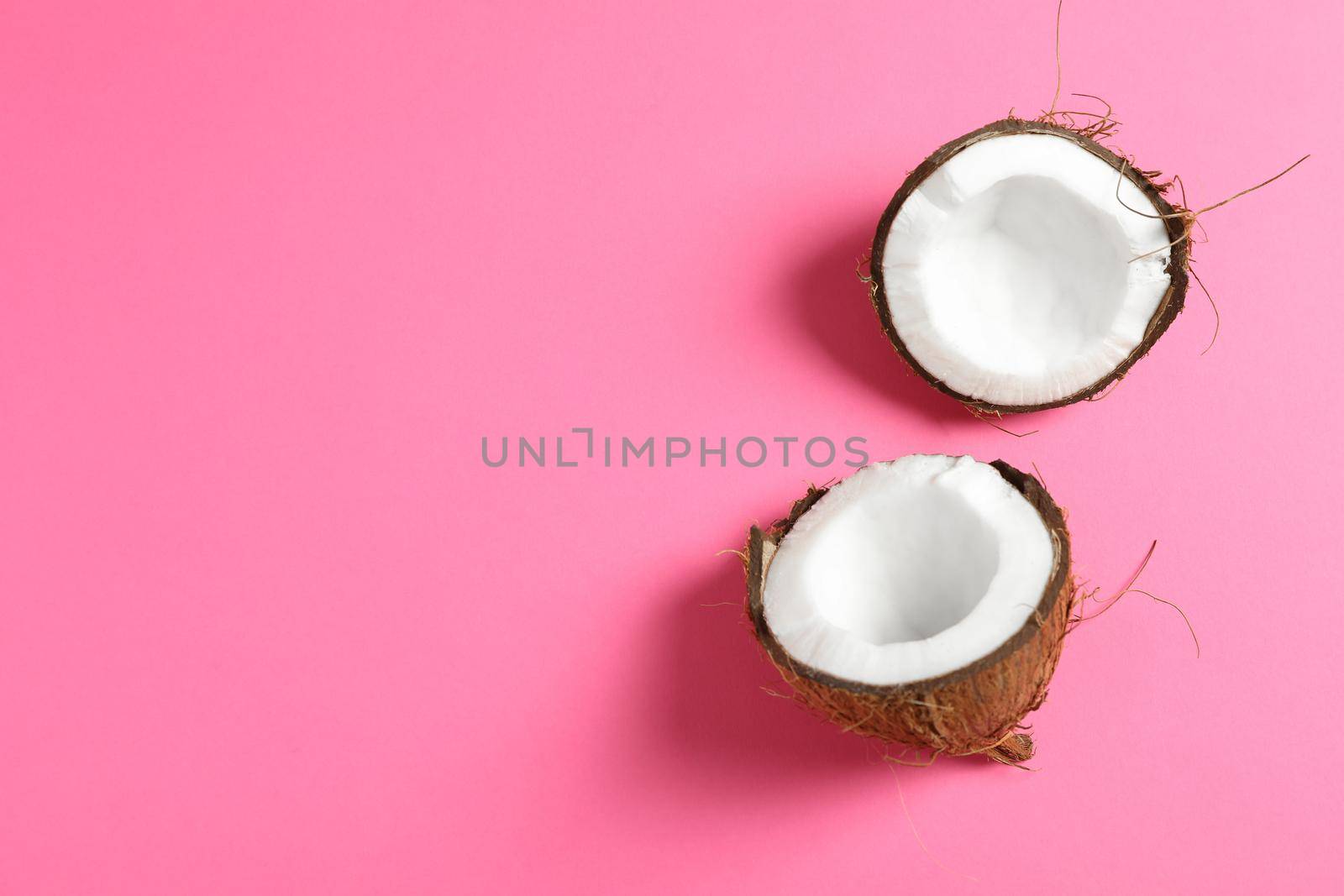 Split tropical coconut on color background, space for text by AtlasCompany