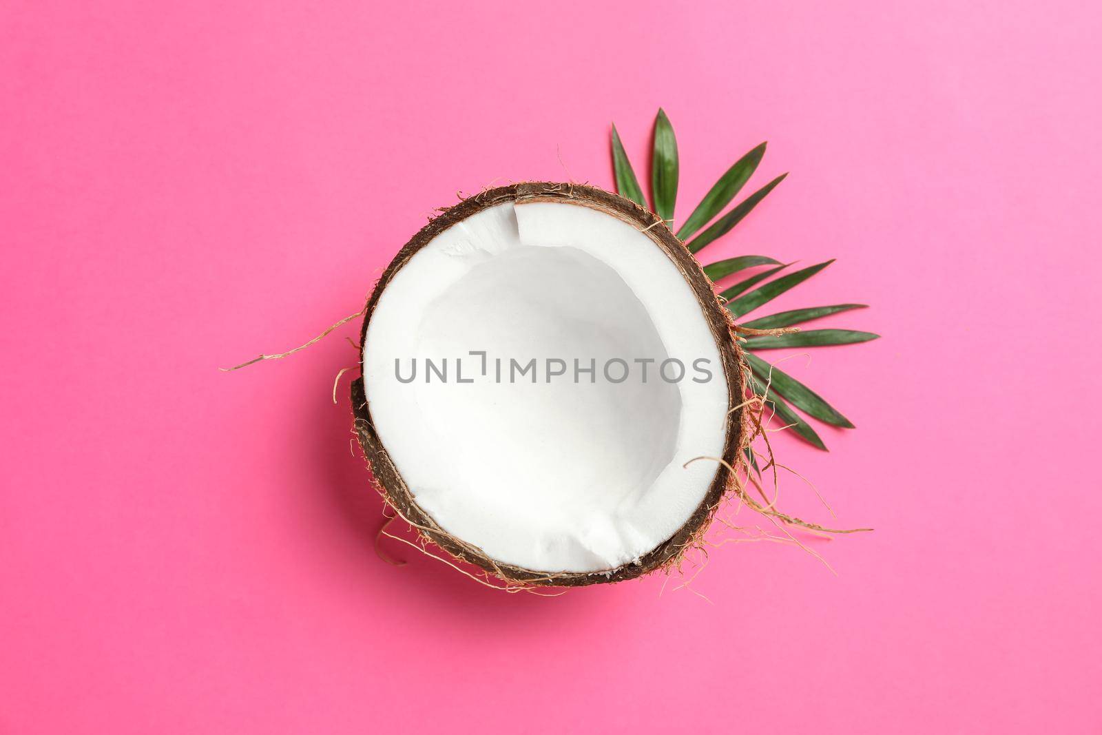 Half tropical coconut on color background, space for text