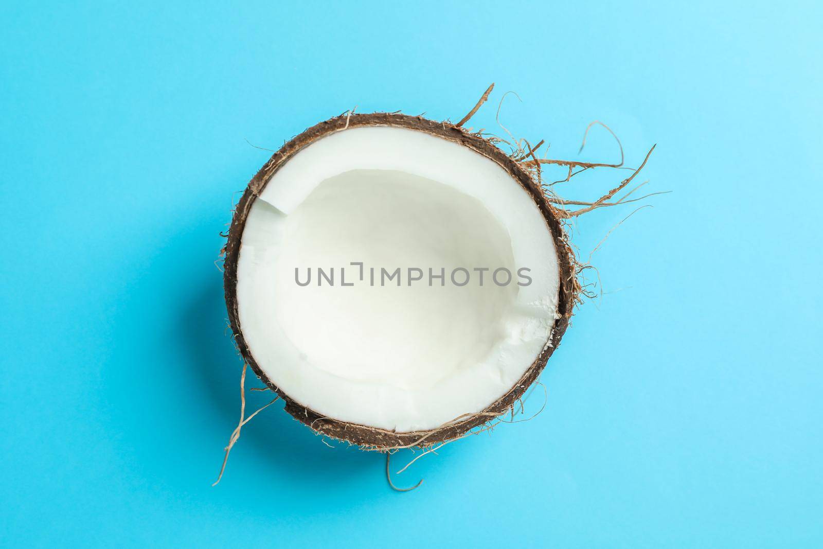 Half tropical coconut on color background, space for text by AtlasCompany