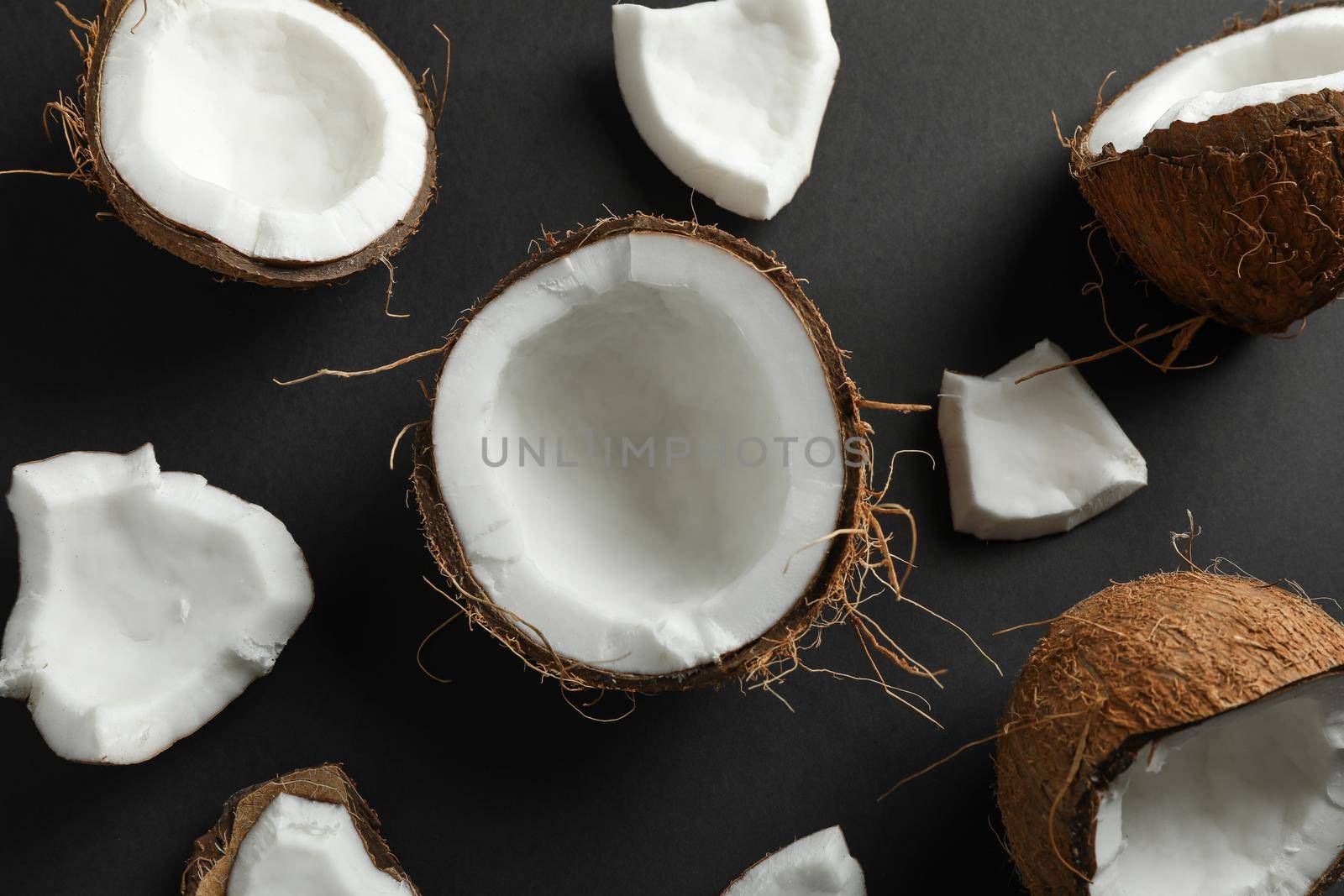 Flat lay composition with coconuts on black background, closeup by AtlasCompany