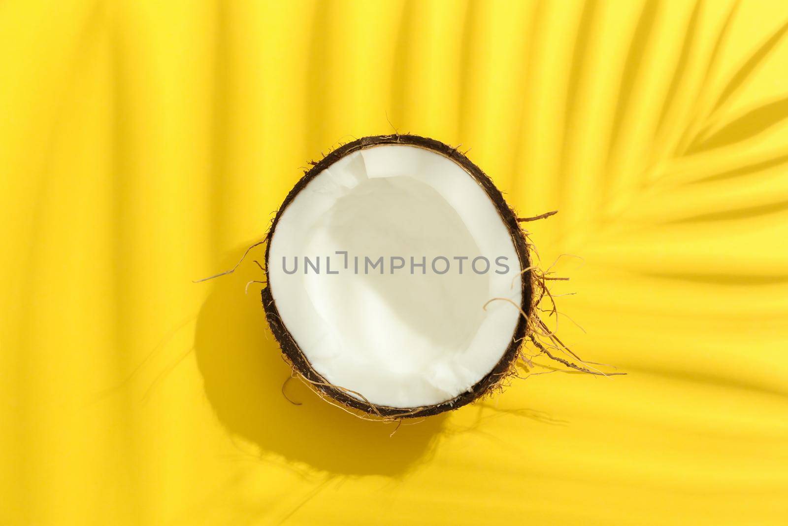 Half tropical coconut on color background, space for text