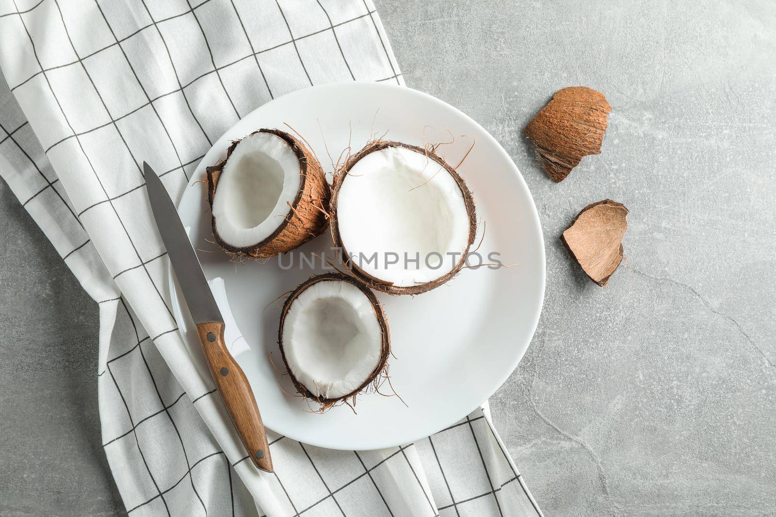 Plate with tropical coconuts on grey background, top view by AtlasCompany