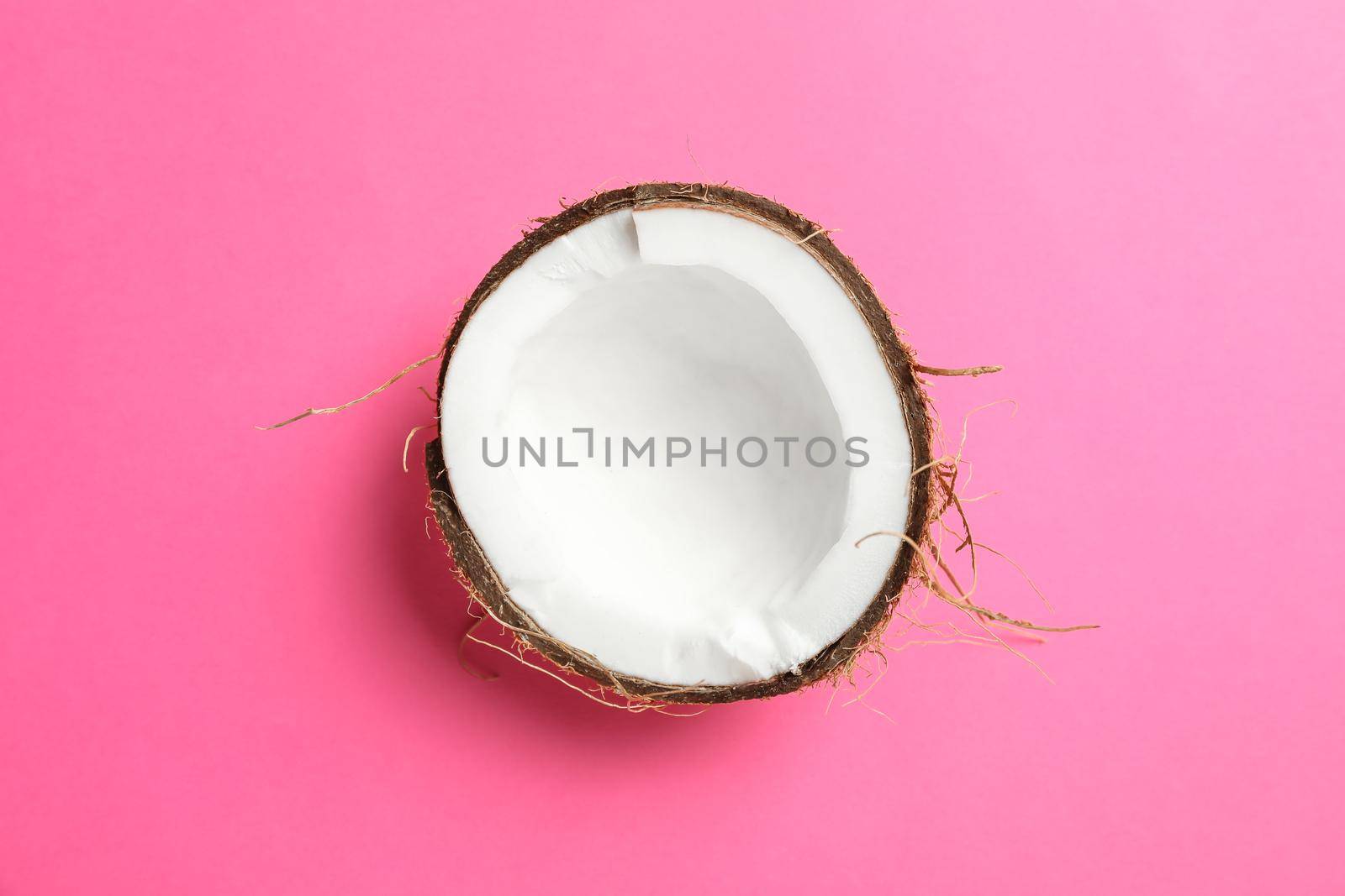 Half tropical coconut on color background, space for text