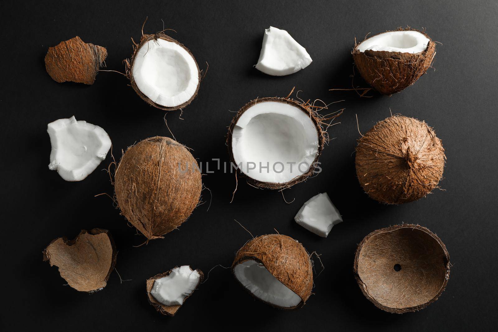 Flat lay composition with coconuts on black background