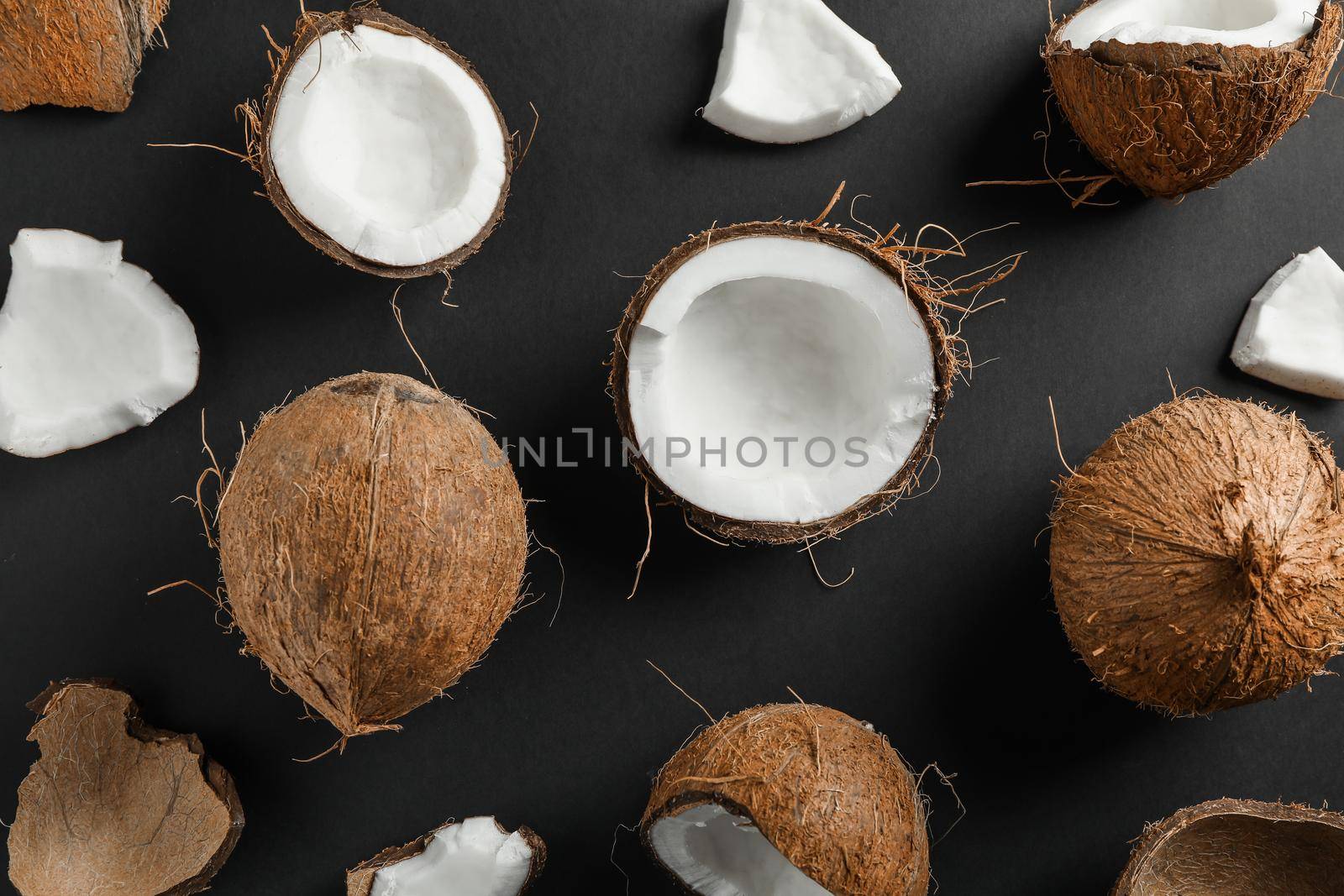 Flat lay composition with coconuts on black background