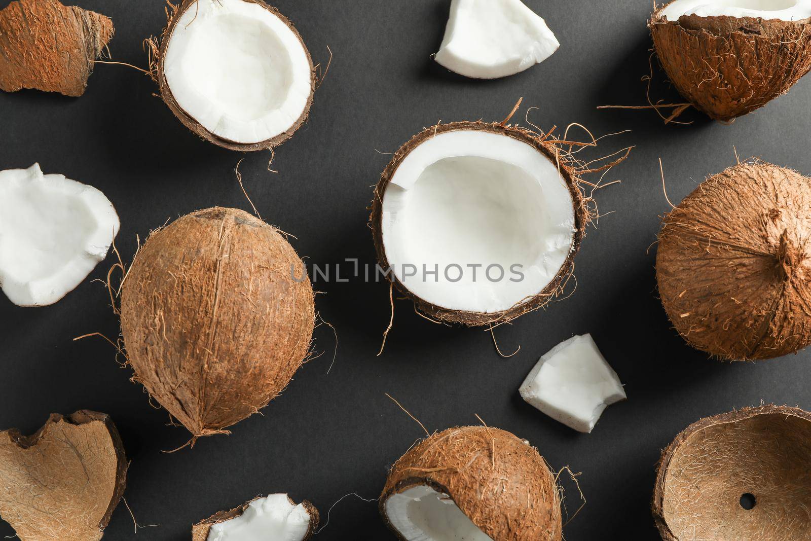Flat lay composition with coconuts on black background