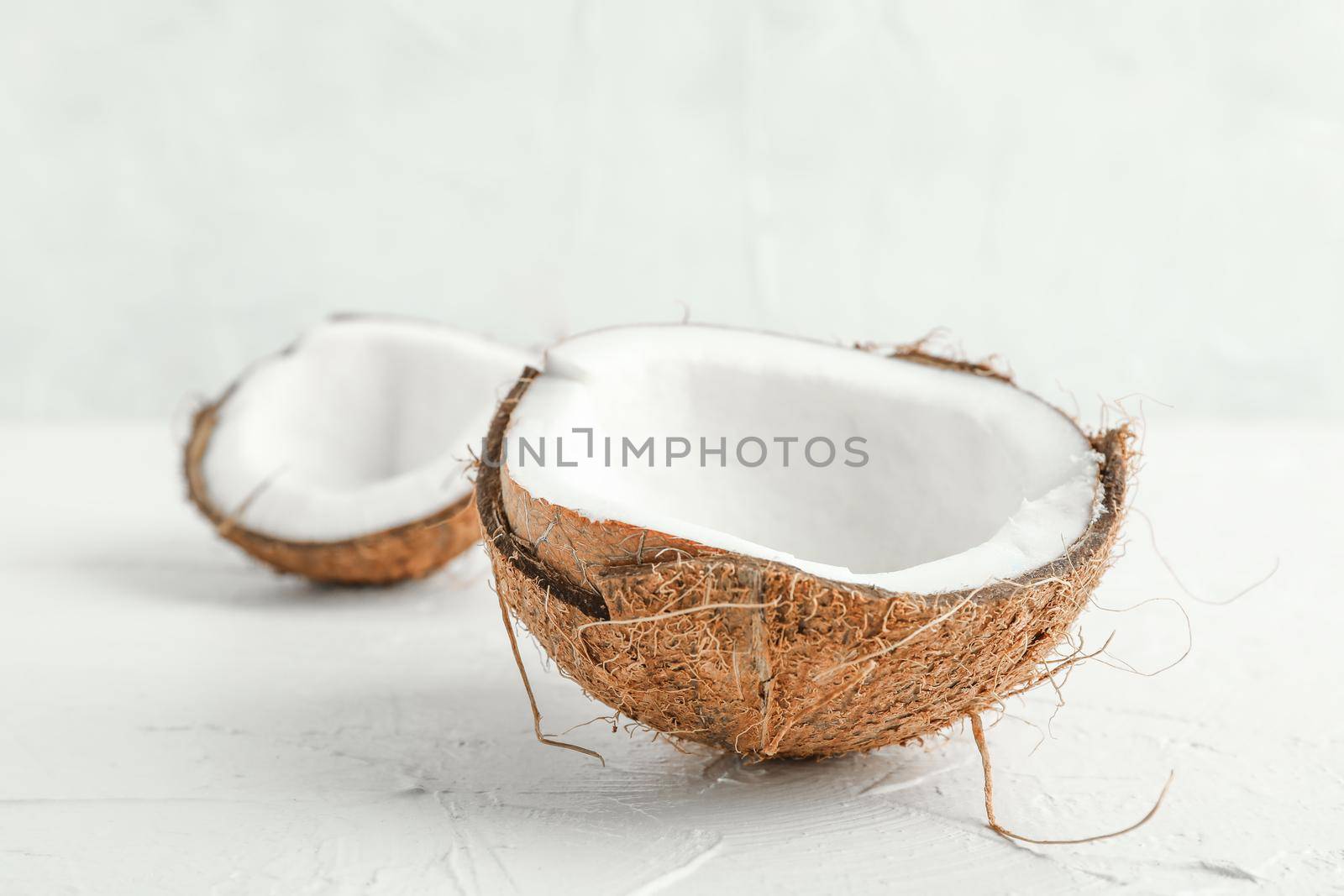 Half tropical coconut on wooden table against white background, space for text