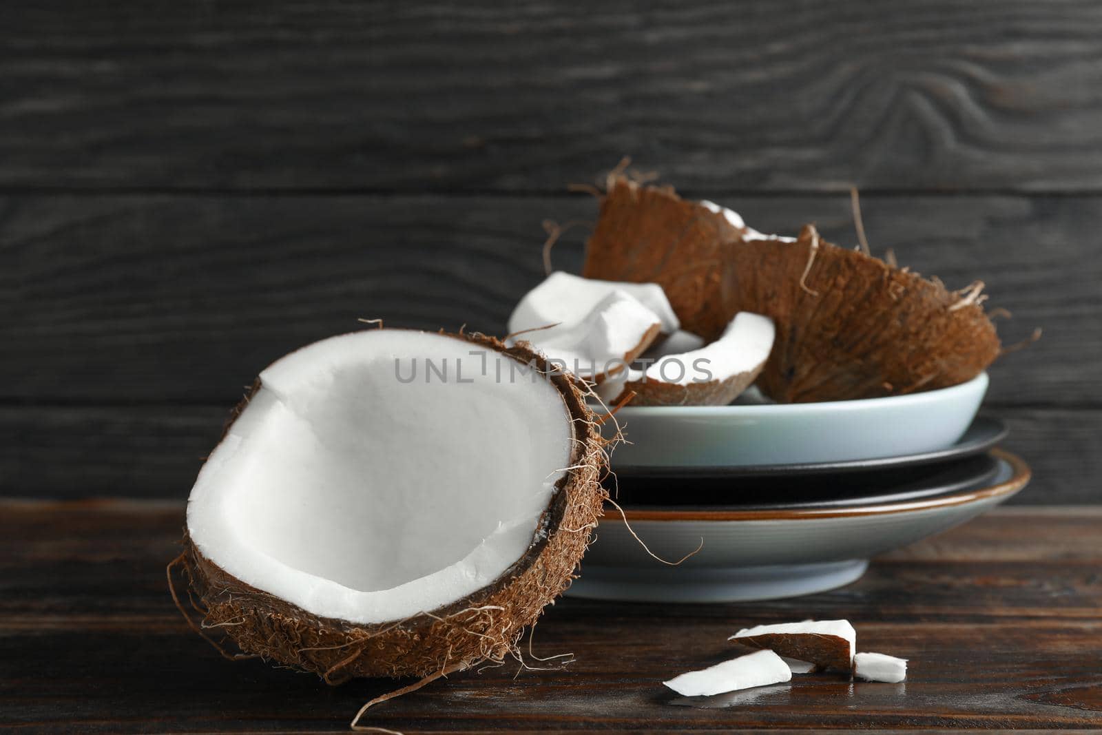 Coconuts on wooden table against dark background