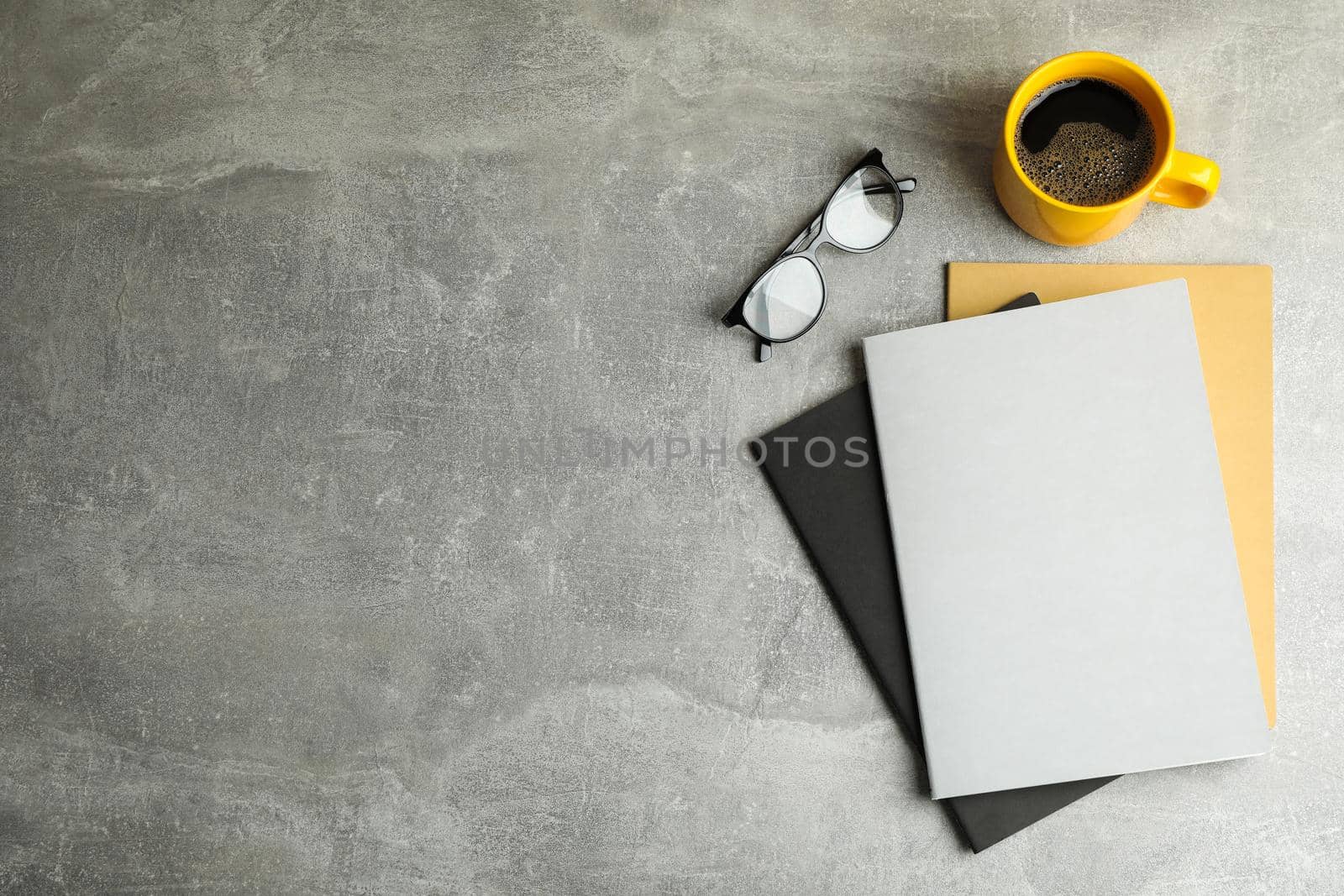 Flat lay composition with cup of coffee, copybooks and glasses, space for text