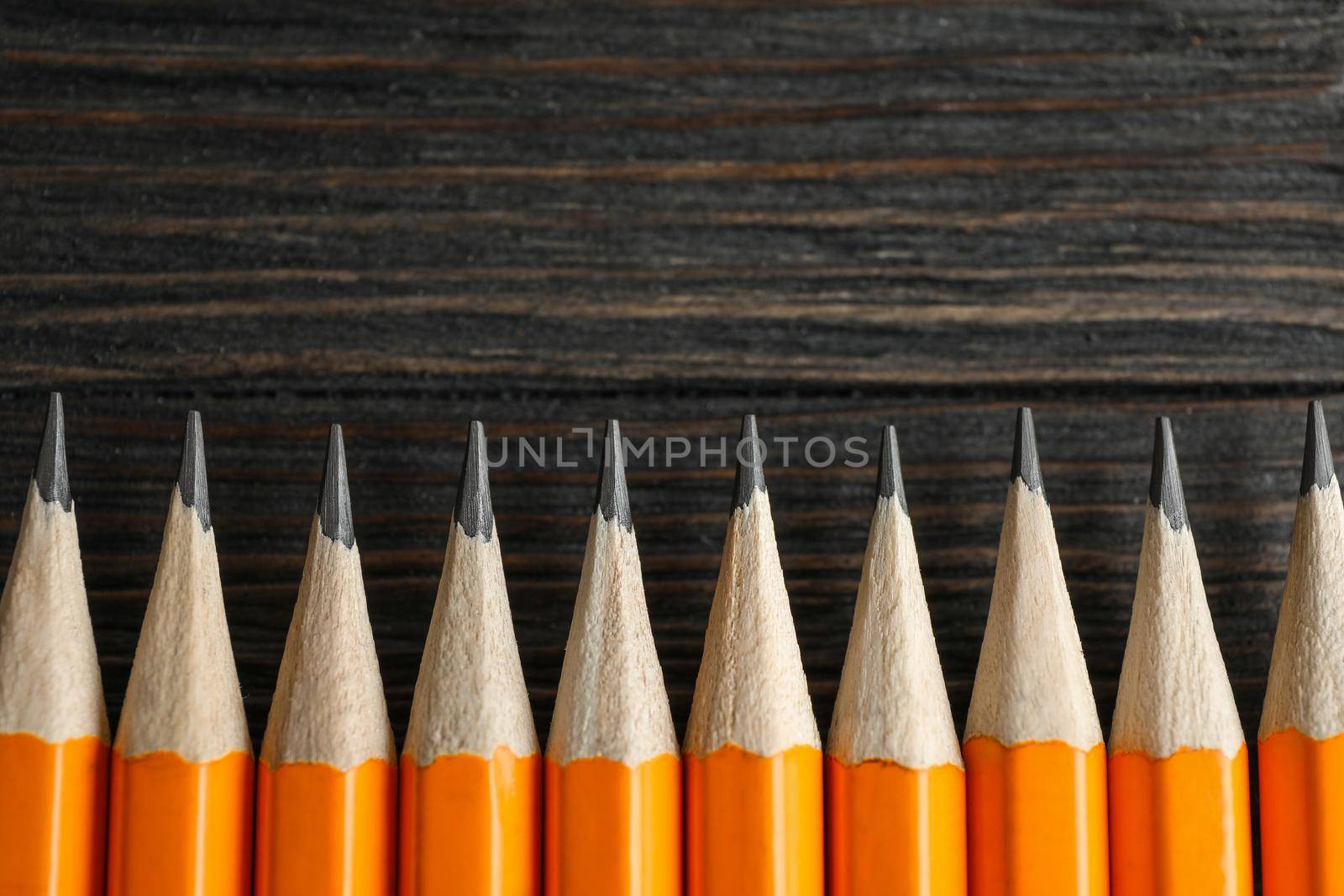 Sharpened pencils on wooden background, space for text