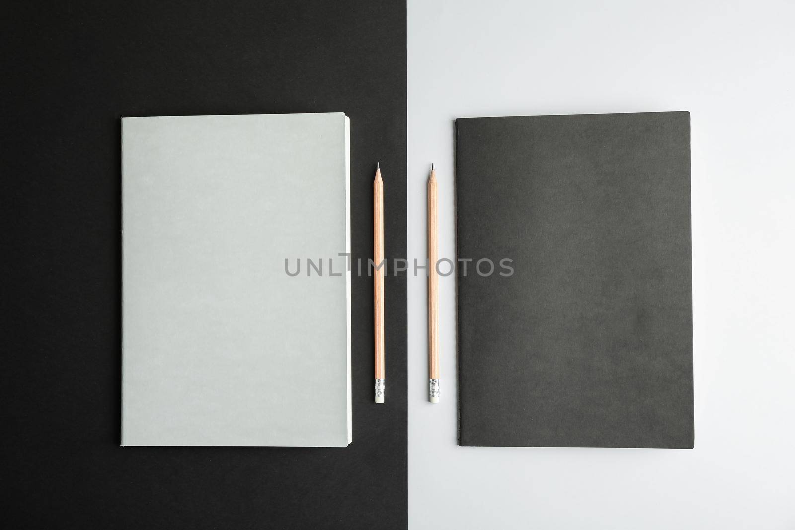 Copybooks with pencils on two tone background, top view by AtlasCompany