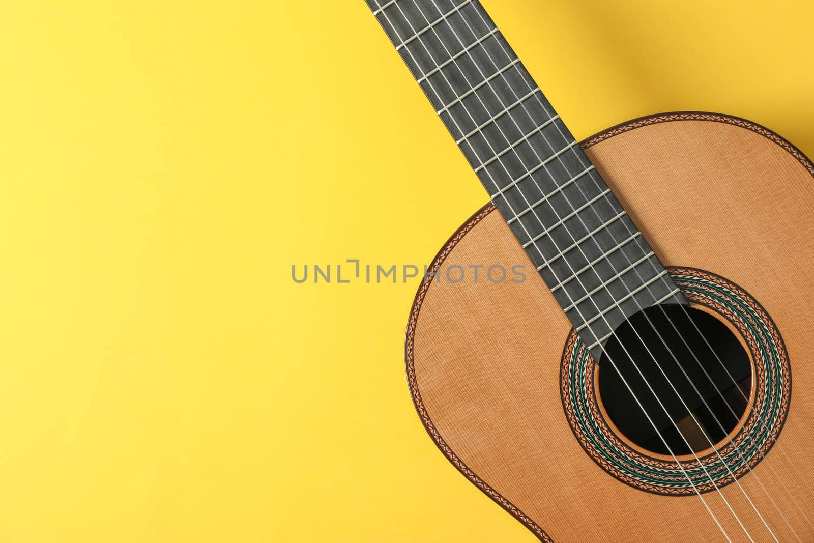 Beautiful classic guitar on yellow background, space for text