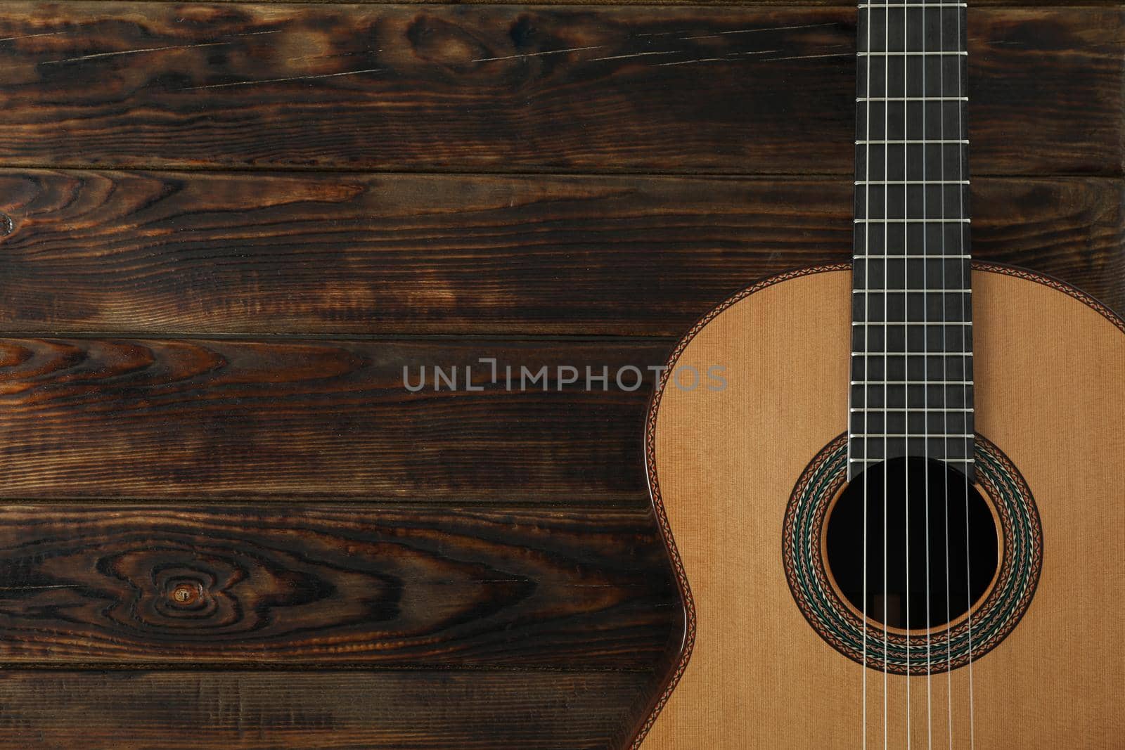 Beautiful six - string classic guitar on wooden background, space for text by AtlasCompany