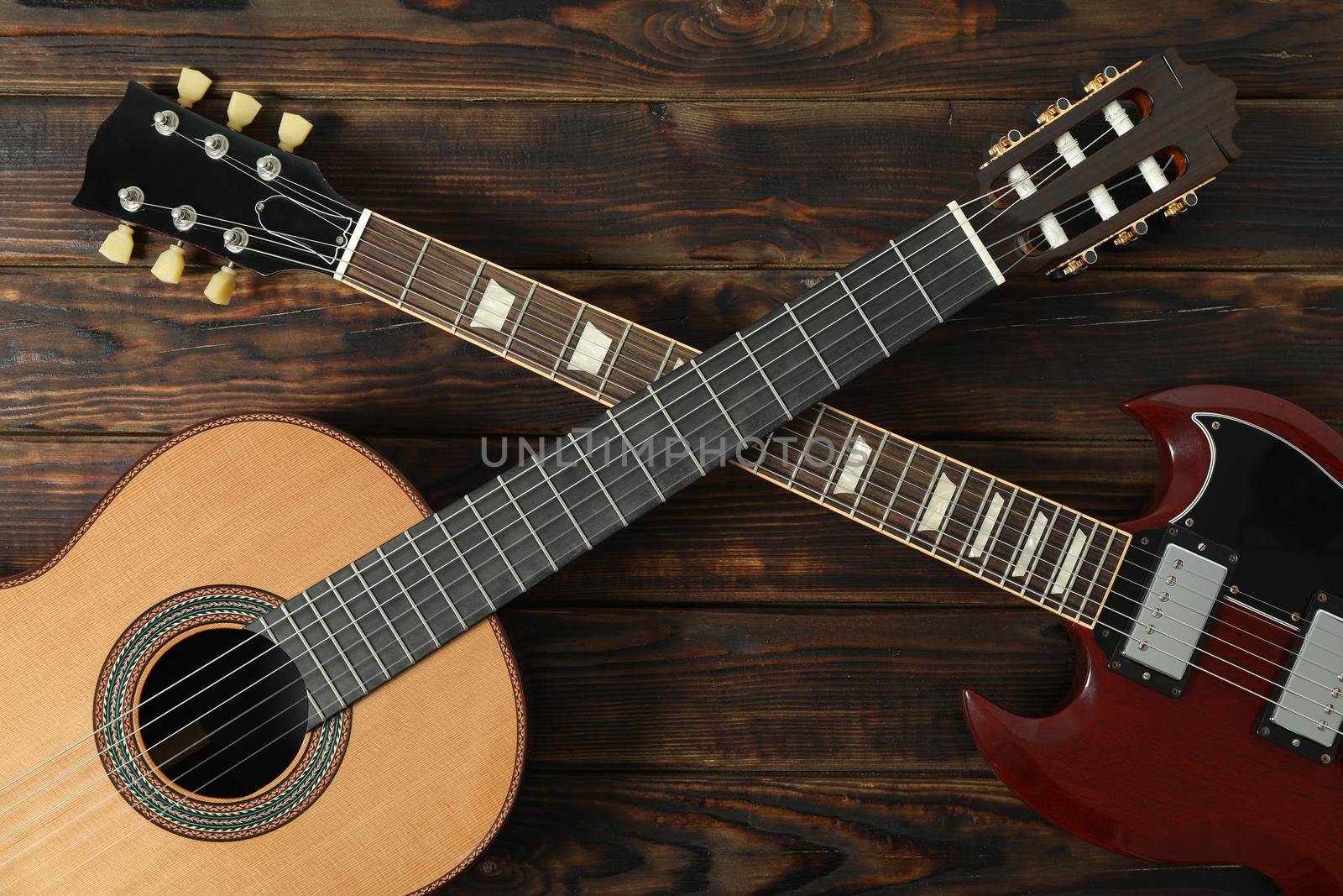 Electric and classic guitar on wooden background, top view