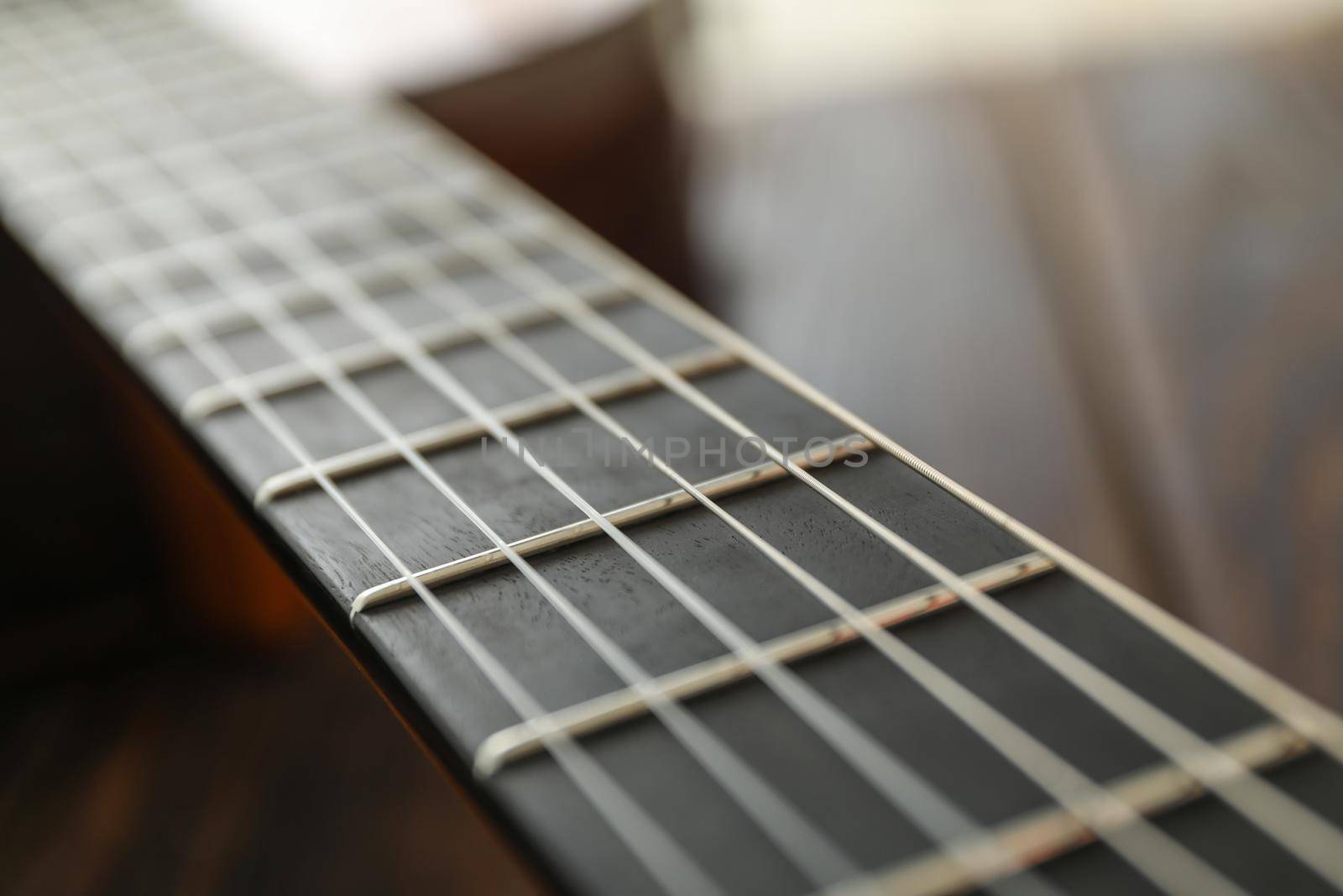 Guitar neck against wooden background, space for text by AtlasCompany