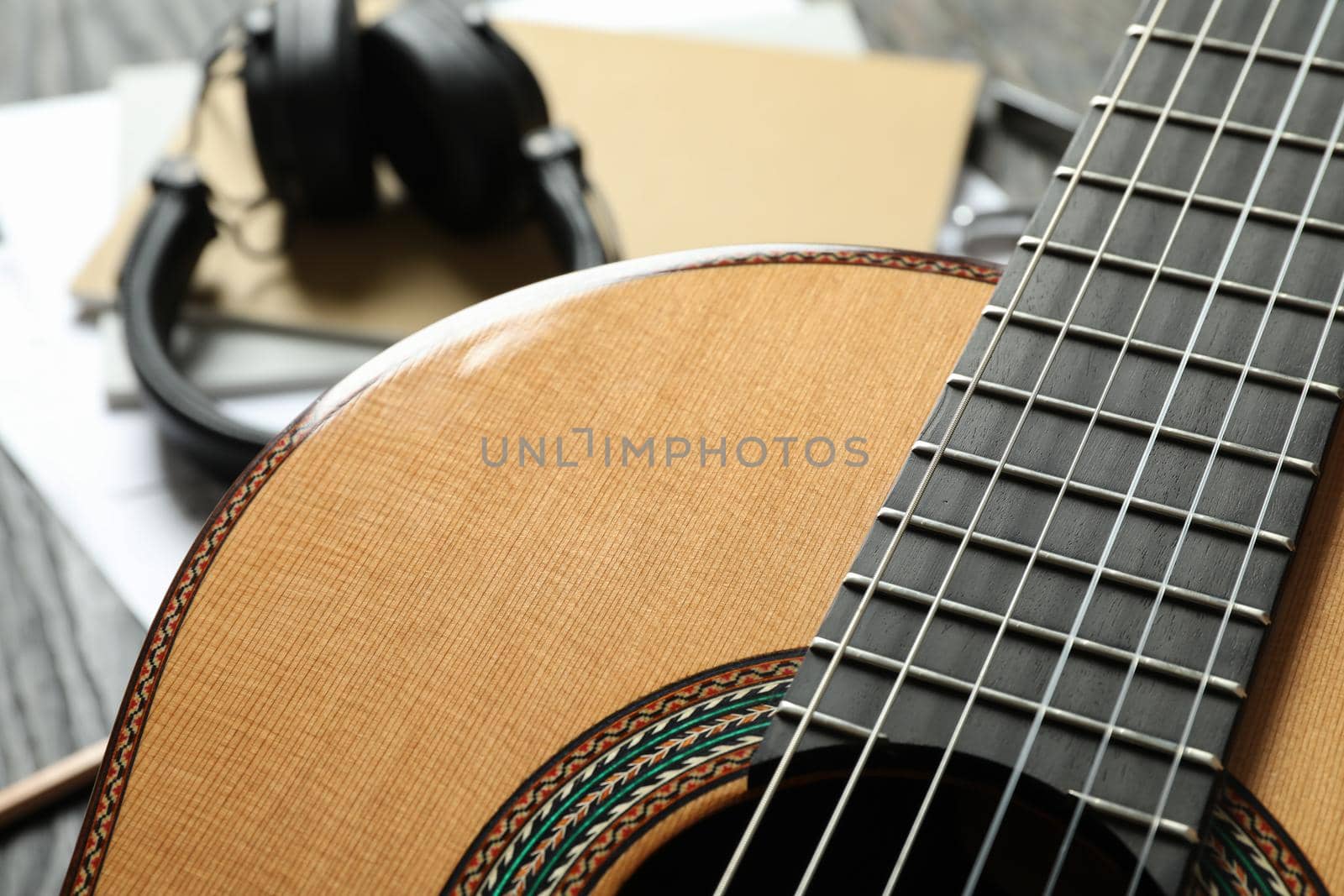 Classic guitar and music maker accessories against wooden background, closeup