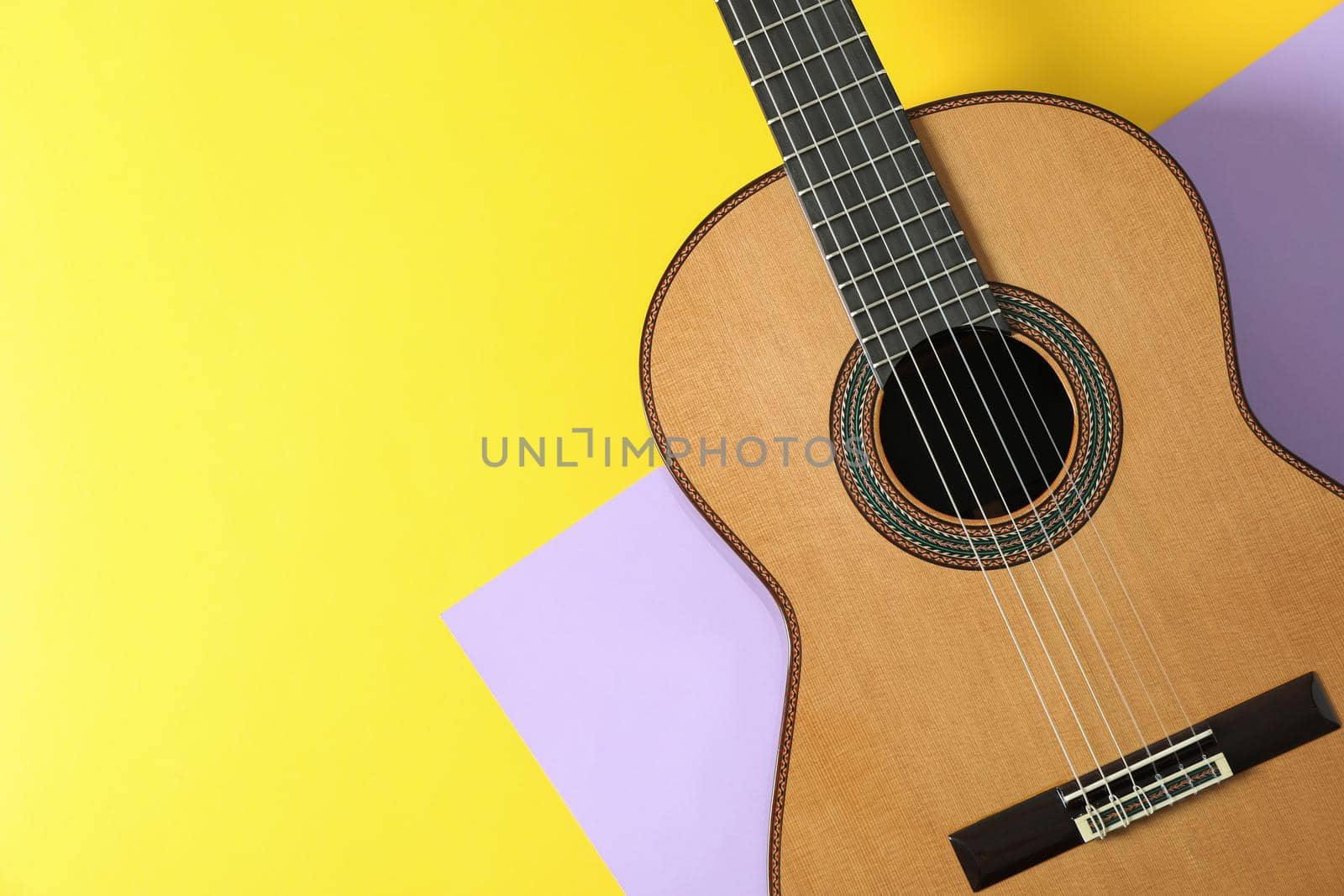 Beautiful classic guitar on two tone background, space for text by AtlasCompany