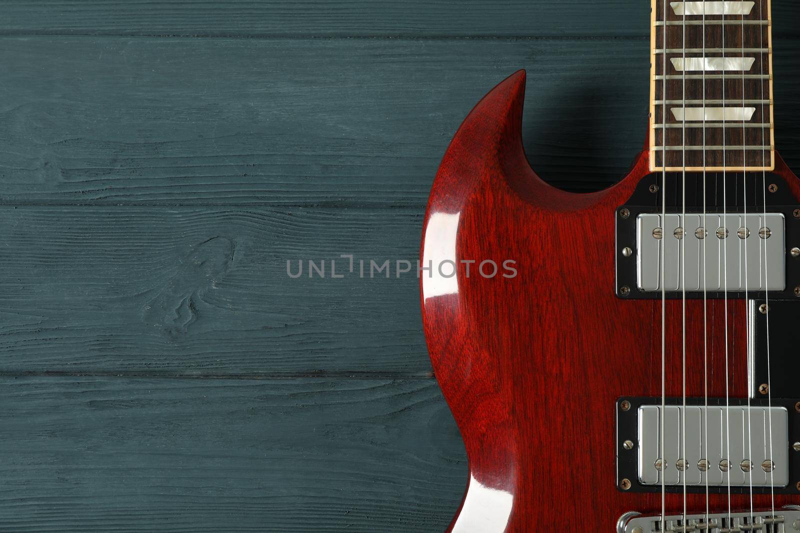 Beautiful six - string electric guitar on wooden background, space for text by AtlasCompany