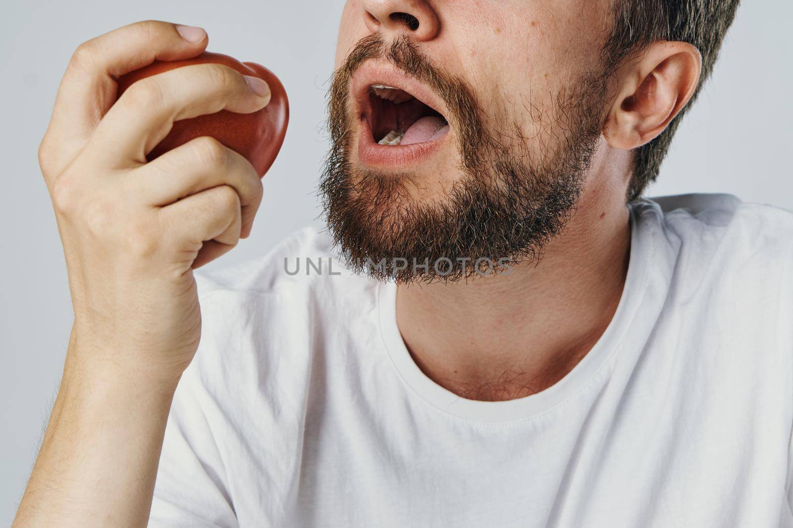 Bearded man in white t-shirt vegetables diet health vegetarian. High quality photo