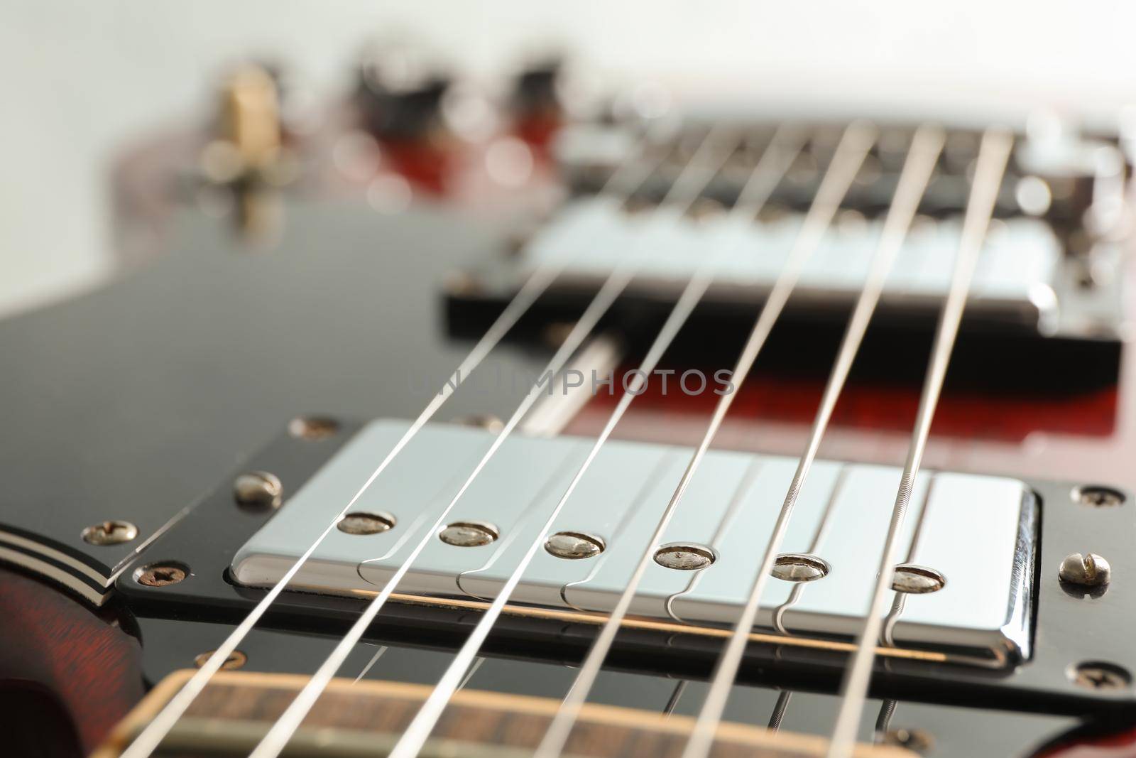 Beautiful six - string electric guitar on white background, closeup