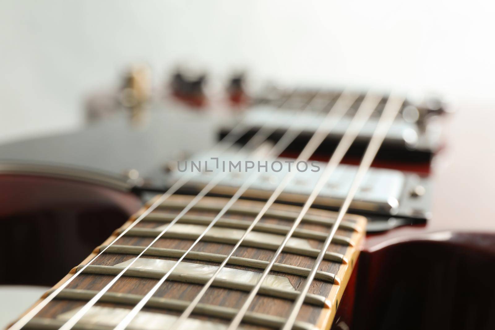 Beautiful six - string electric guitar on white background, closeup