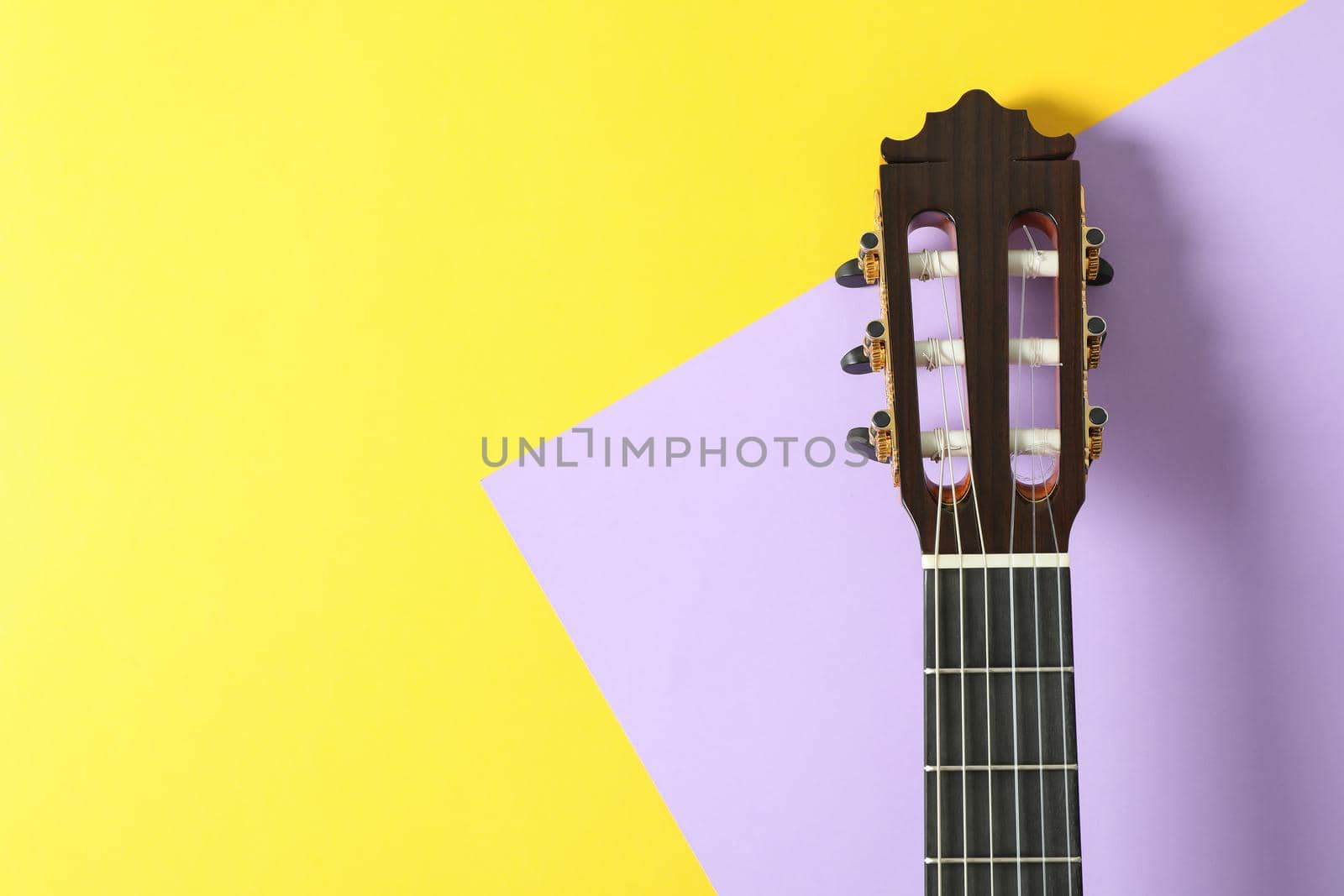 Guitar neck on two tone background, space for text by AtlasCompany