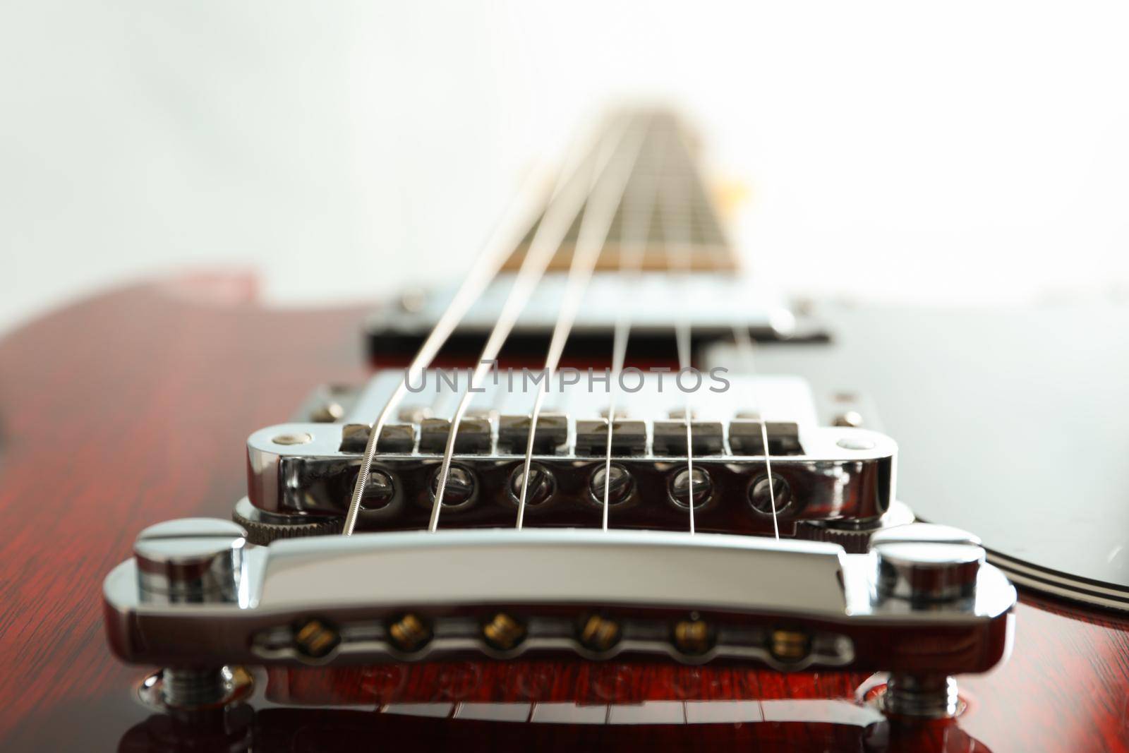 Beautiful six - string electric guitar on white background, closeup