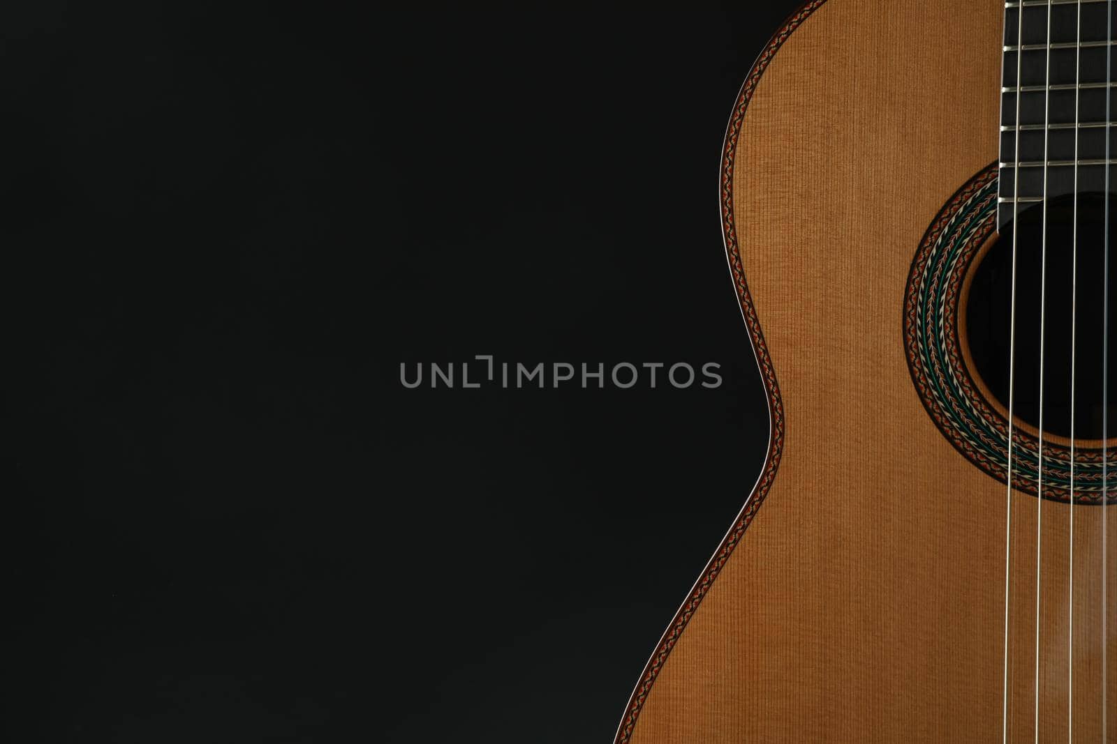 Beautiful six - string classic guitar against dark background, space for text