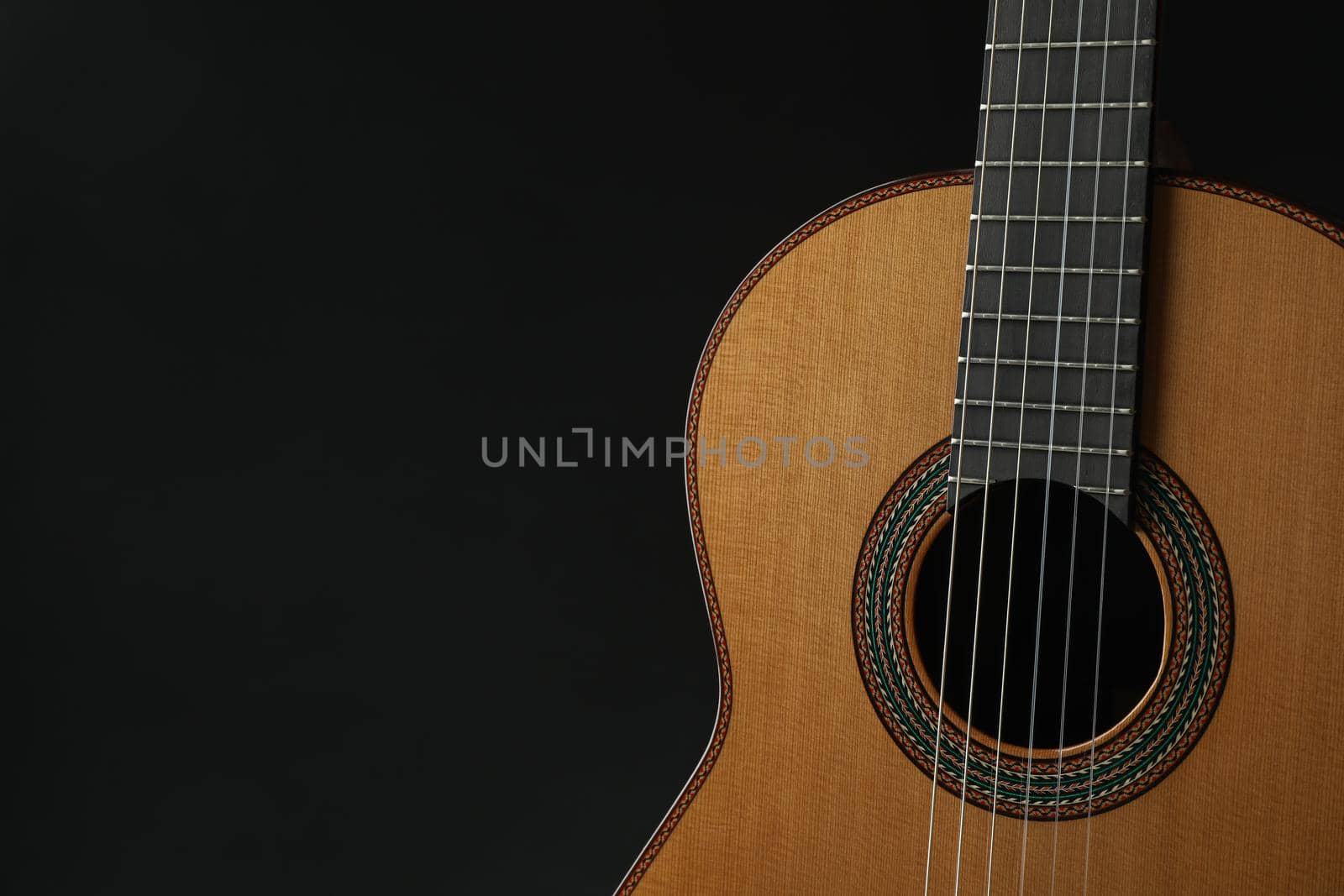 Beautiful six - string classic guitar against dark background, space for text