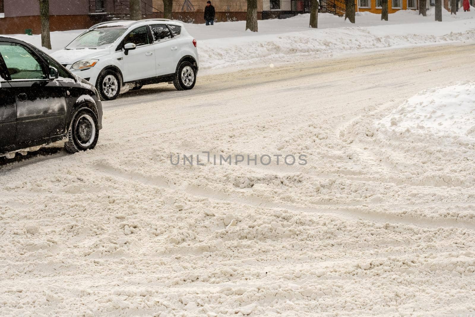 Stuck cars under the snow and ice. City street after blizzard. Buried vehicle in snowdrift on the road. Parking lots in winter after heavy snowfall. Uncleaned roads. Record-breaking amounts of snow.