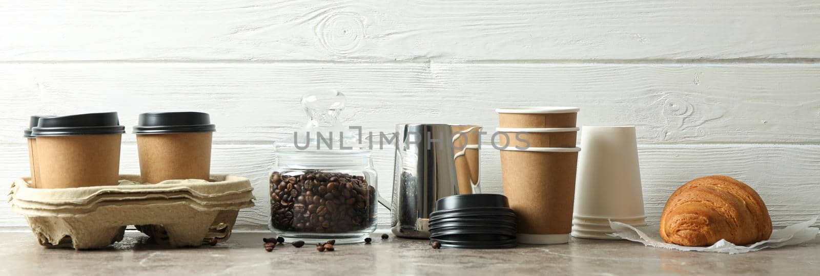 Coffee time accessories on grey table against white wooden background, space for text. Break time